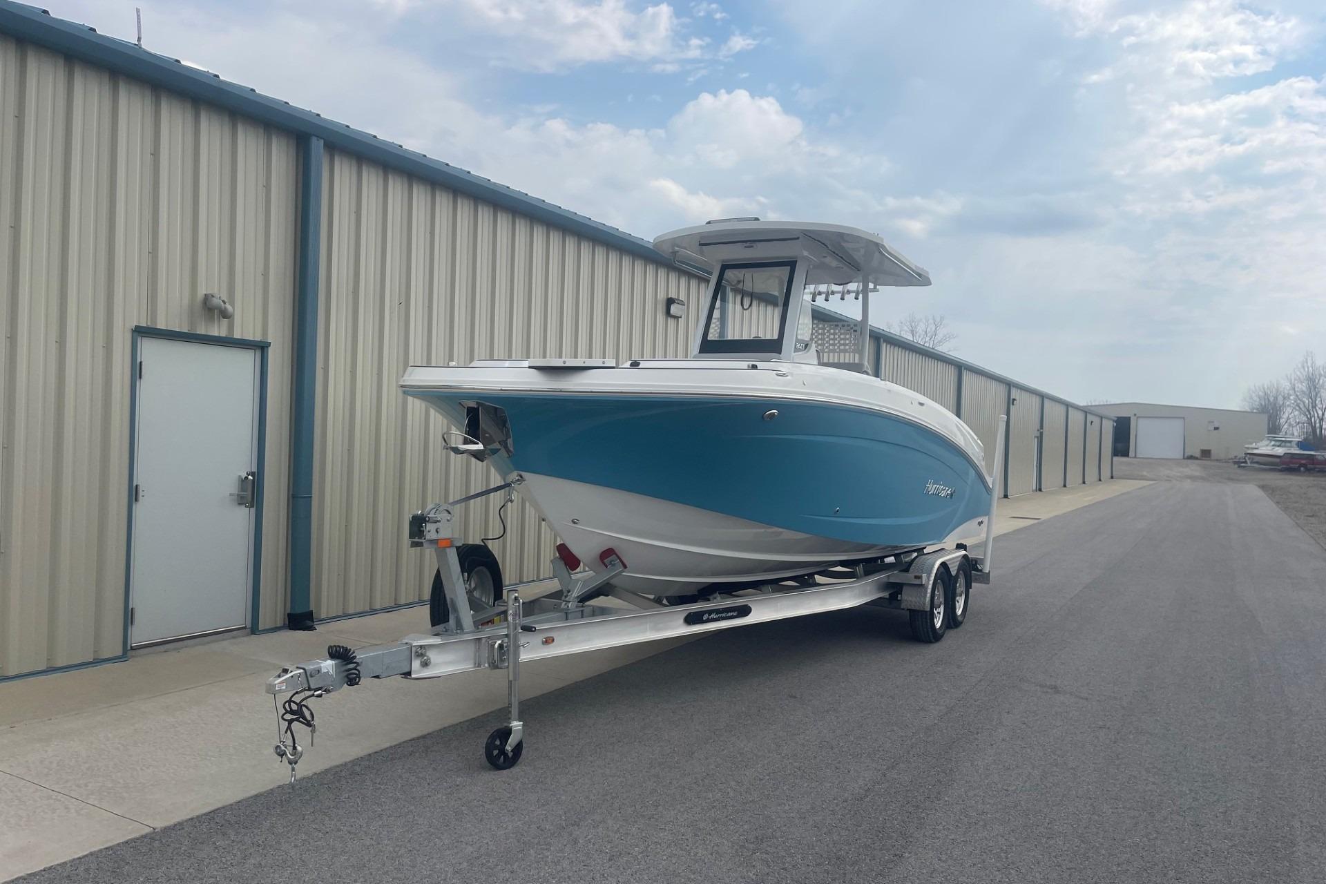 2025 Hurricane Center Console 24 OB boat on trailer near industrial building.