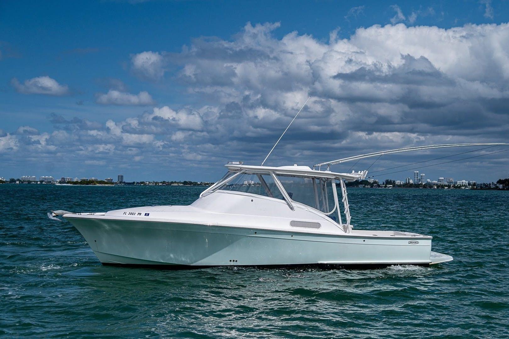 2012 Brooks Boatworks 34 cruising on a sunny day with a city skyline in the background.