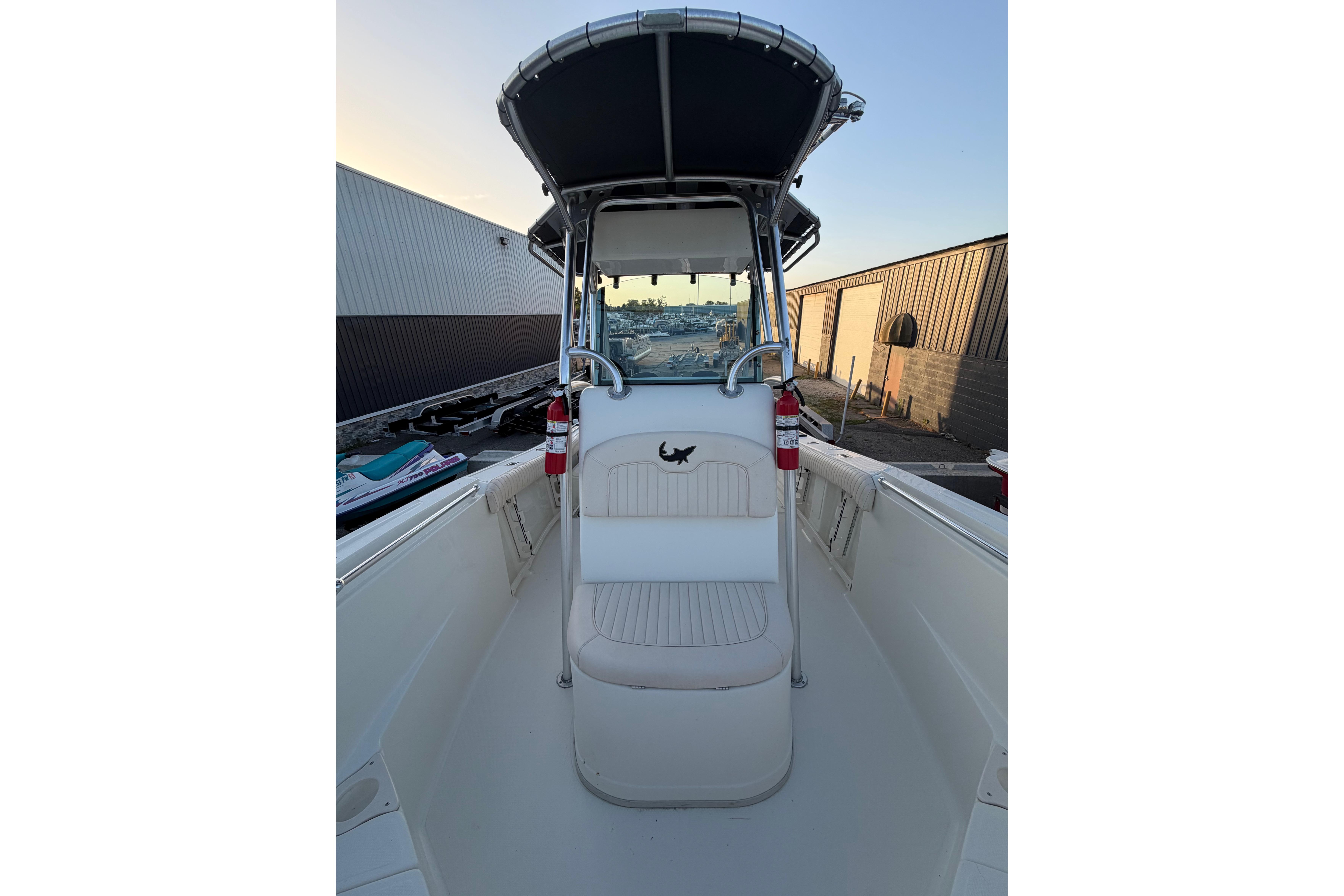2007 Mako 234 Center Console boat with T-top and seating, docked outdoors.
