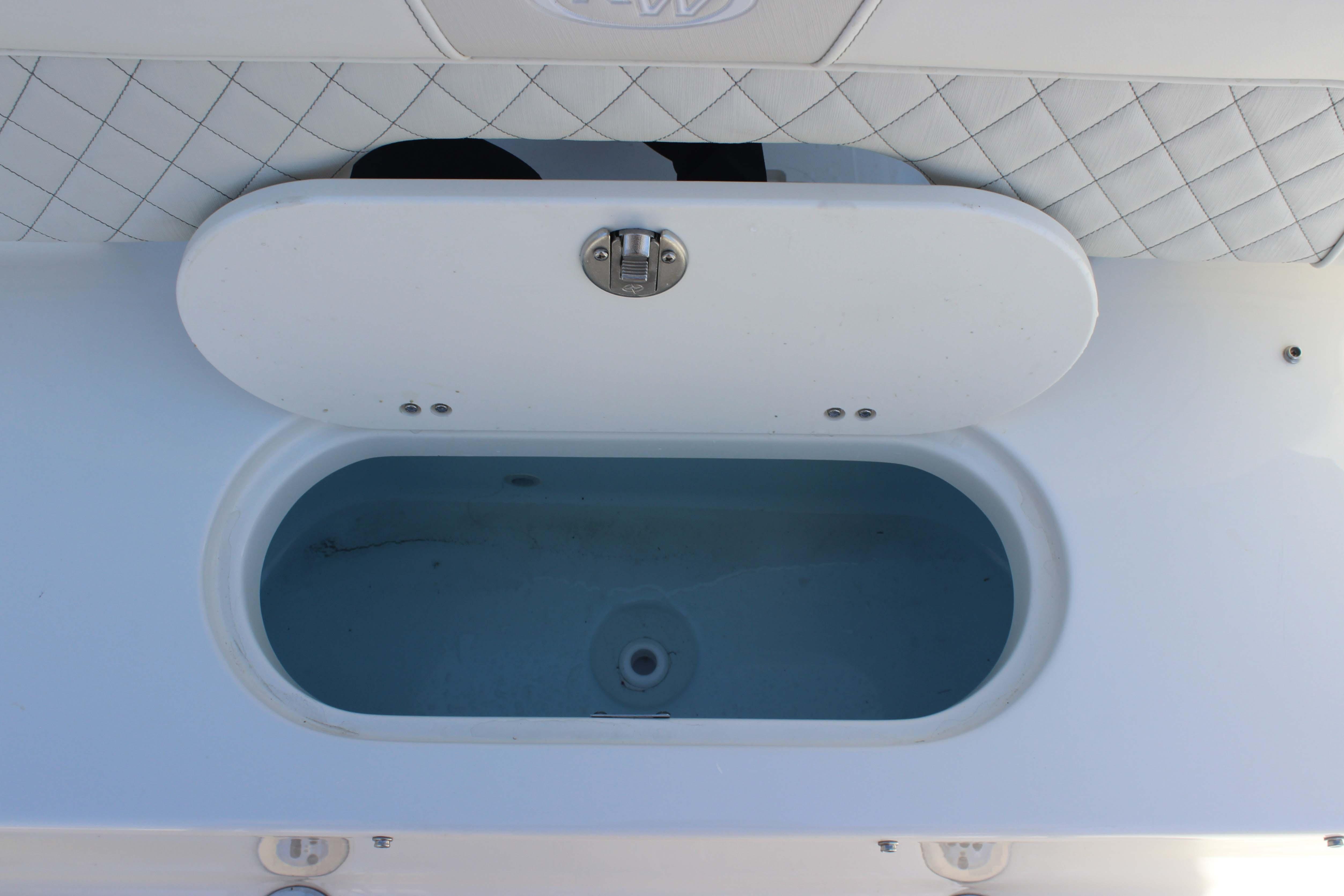 Livewell compartment on a 2026 Key West 203 FS boat, featuring a white lid and quilted upholstery.