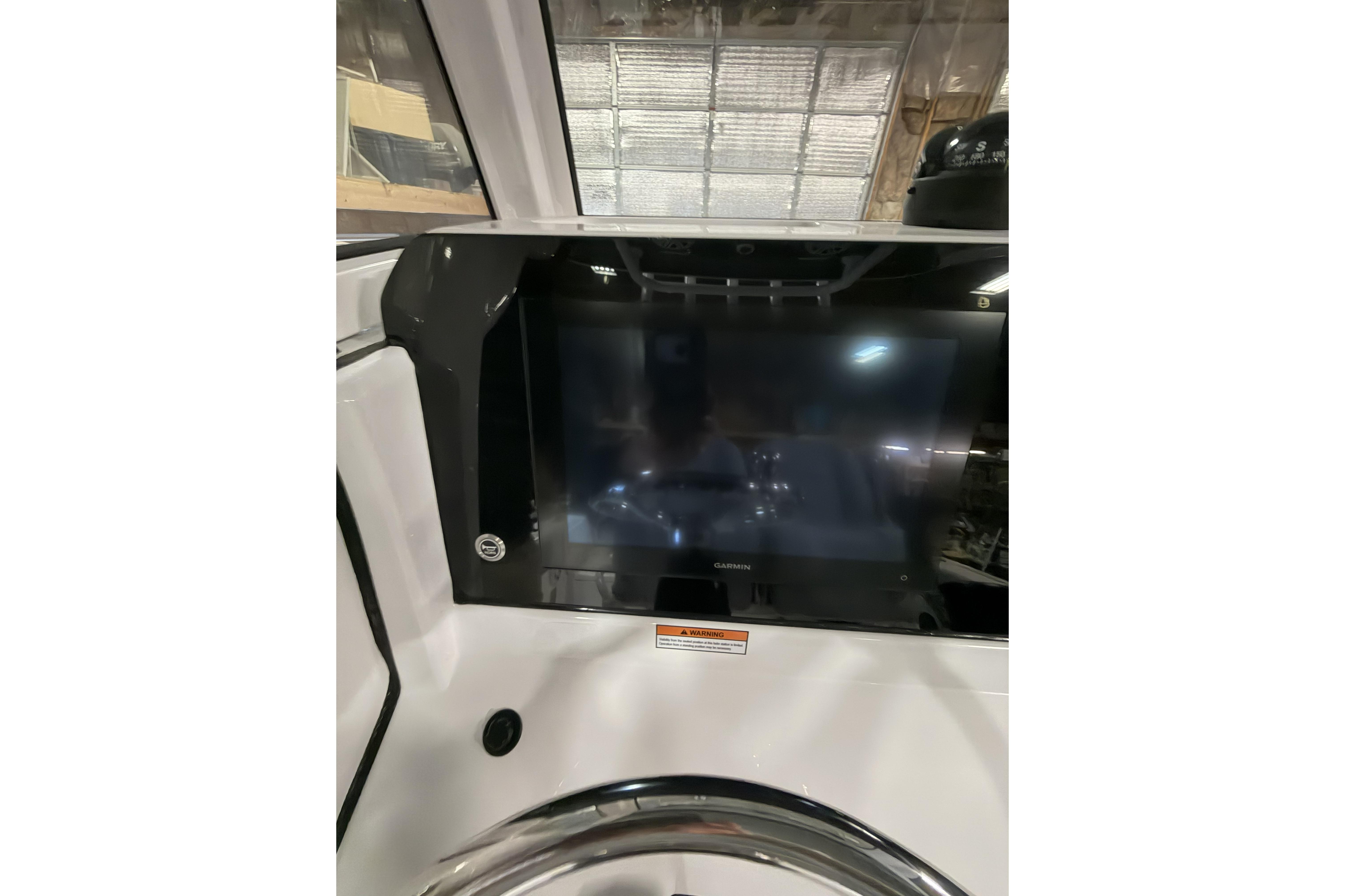 2026 Sportsman Open 232 Center Console dashboard with Garmin display in a boat interior.