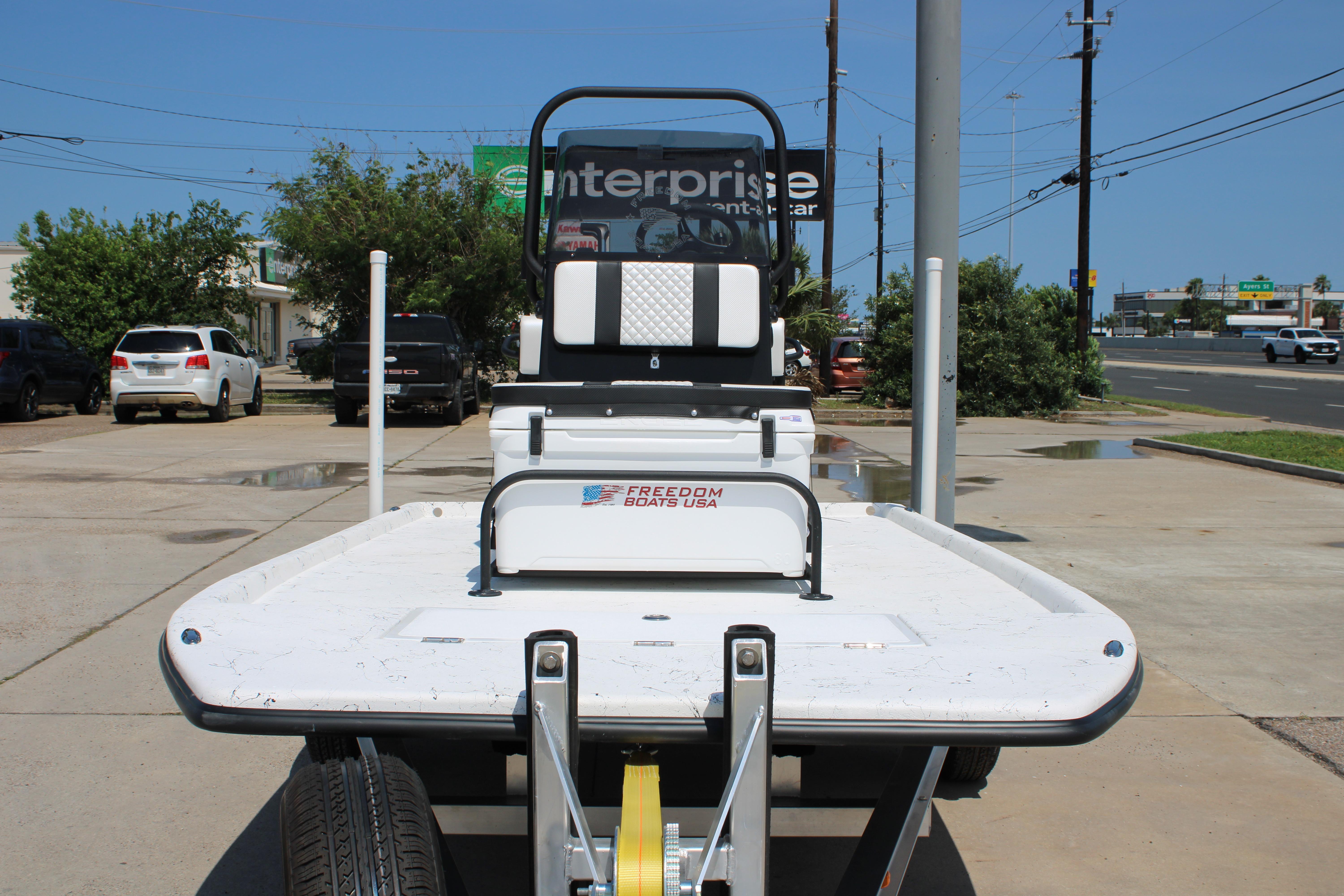2026 Freedom Boats Chiquita on trailer, parked outdoors near Enterprise Rent-A-Car.