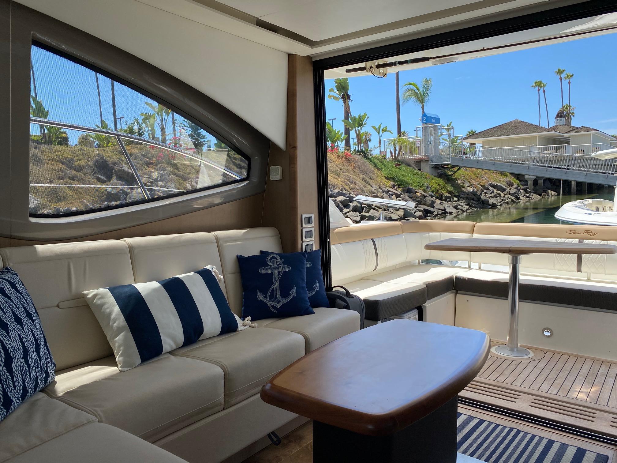 Luxurious interior of 2018 Sea Ray 400 Fly yacht with elegant seating and scenic marina view.
