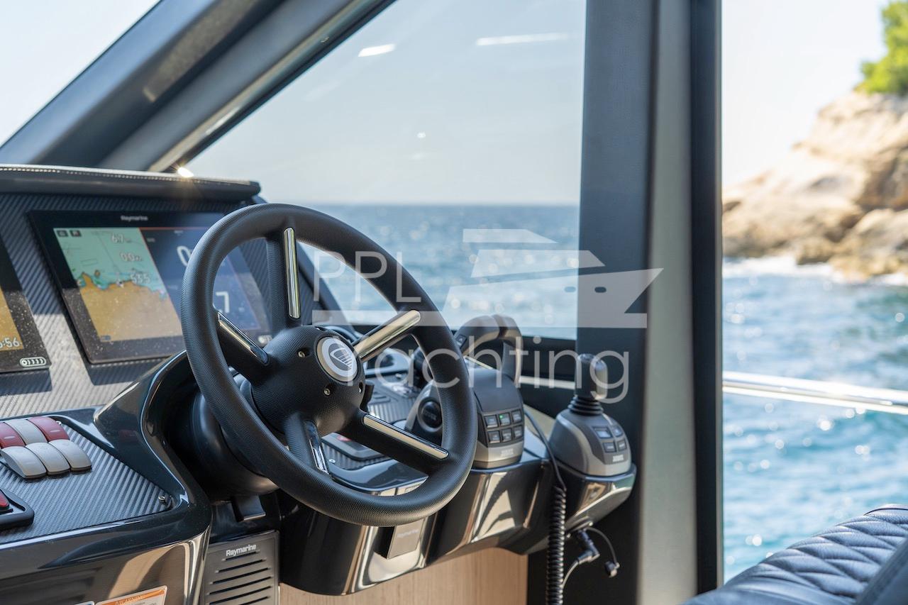 Cockpit of 2021 Absolute 47 Fly yacht with navigation controls and sea view.