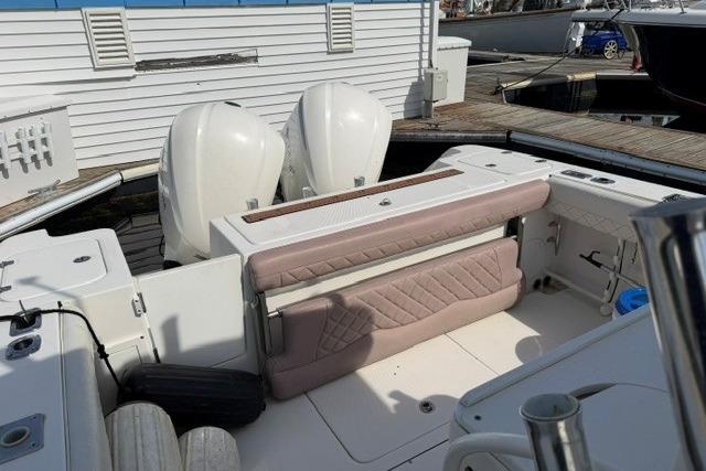 2014 Edgewater 318CC boat with dual engines and cushioned seating at a marina.