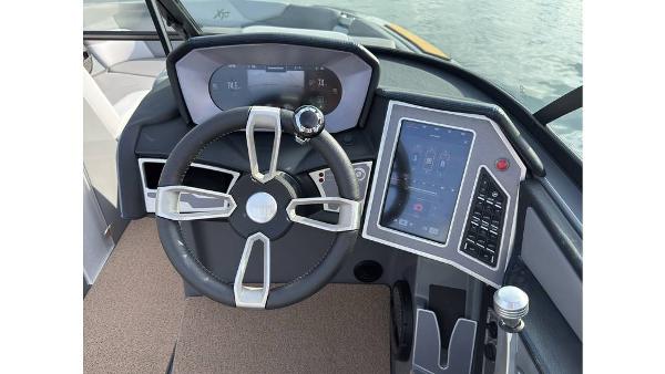 2023 MasterCraft XT22 boat dashboard with steering wheel and touchscreen controls.