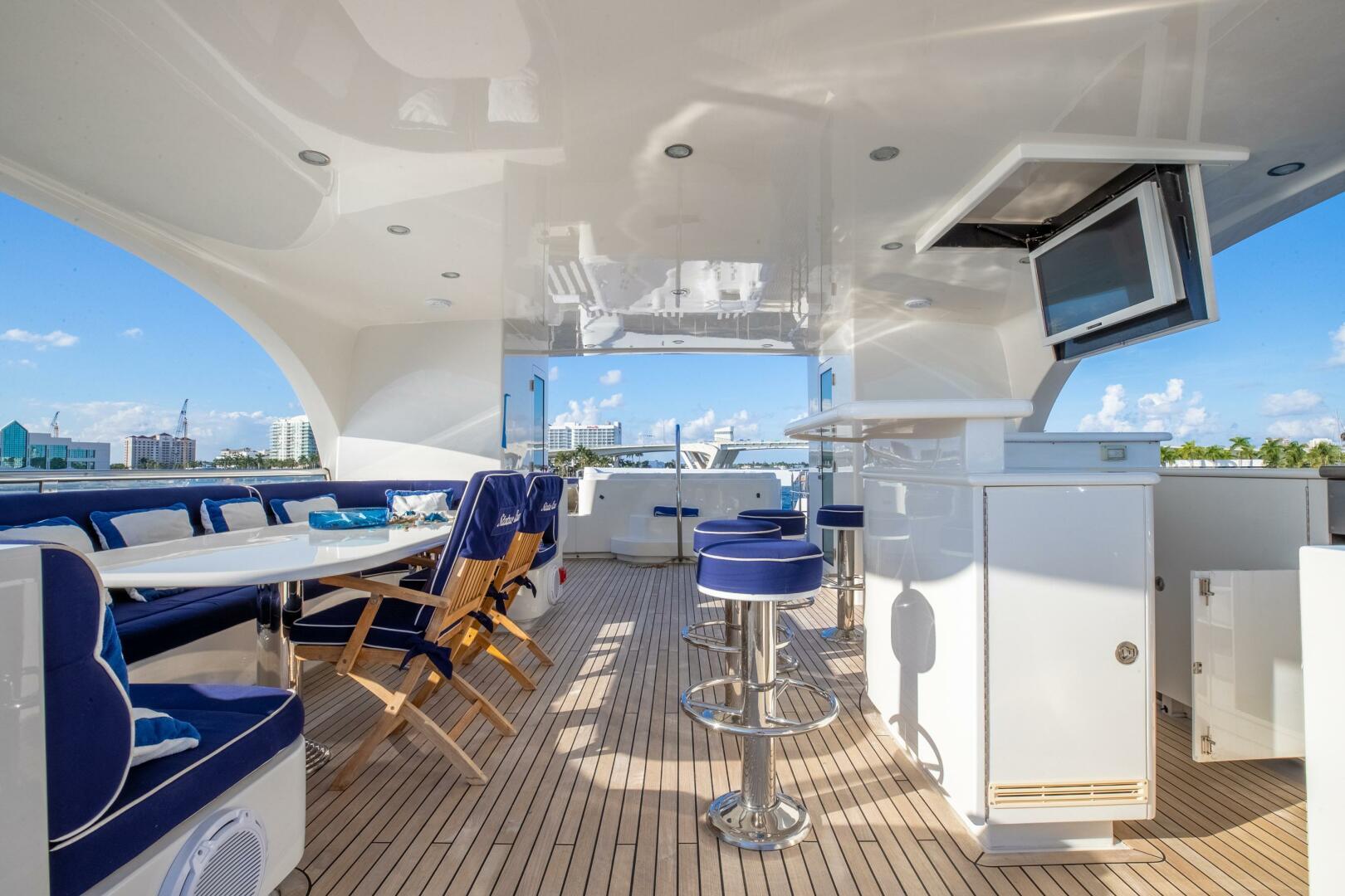 Luxurious 2009 Horizon Model Tri-Deck yacht interior with seating, bar stools, and TV.