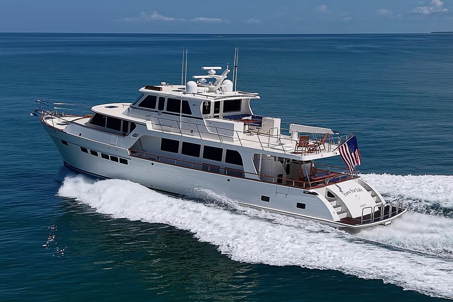 2014 Marlow 80 Explorer yacht cruising on open sea with American flag.