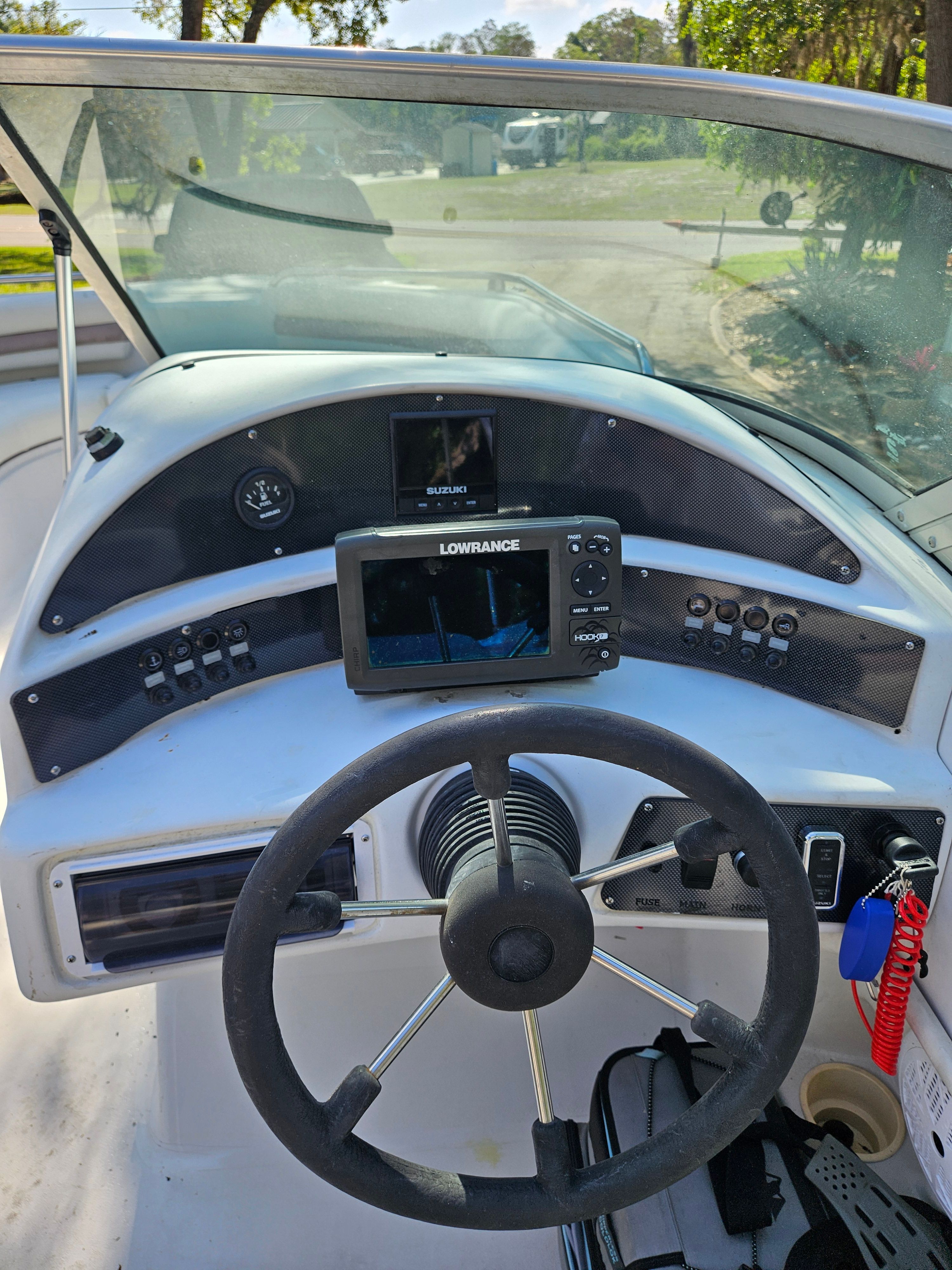 Dashboard of a 2001 Hurricane 237 boat with steering wheel and electronics.