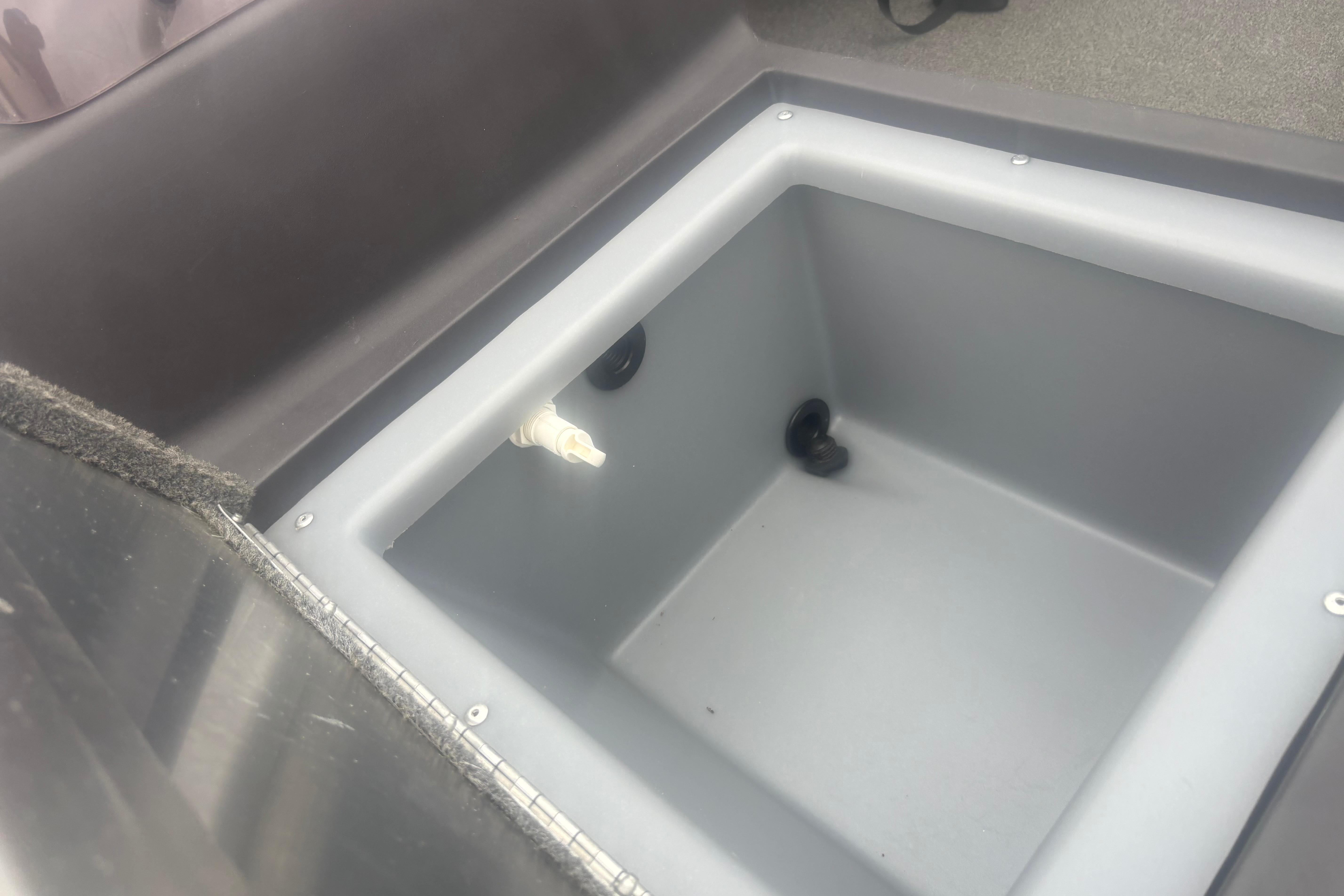 Bass Tracker III Classic 2020 boat compartment, gray interior with drain plug.