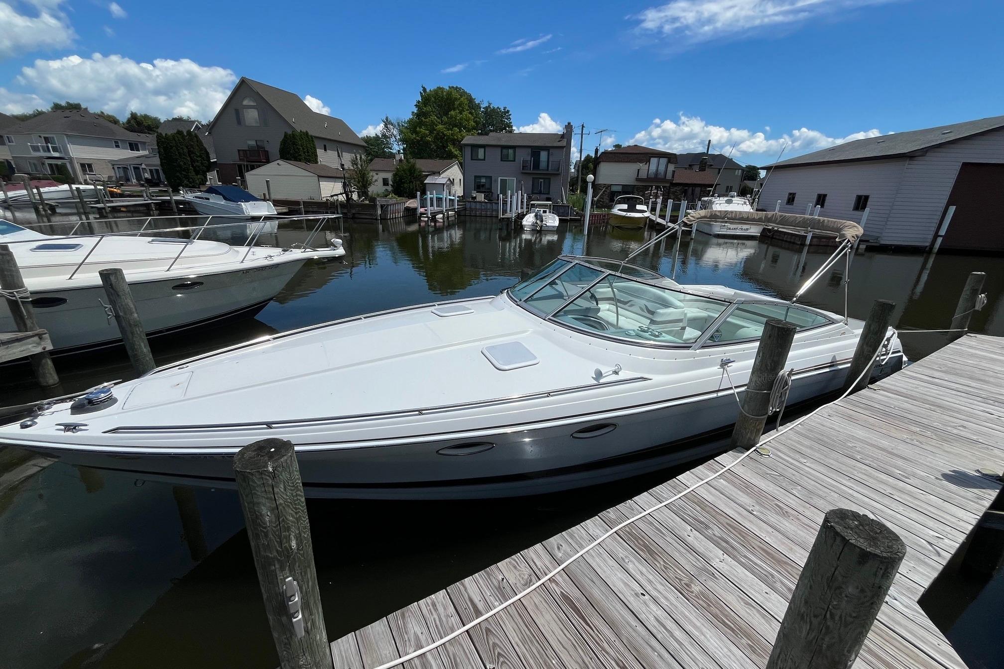 2002 Formula 330 Sun Sport boat docked in a marina under a clear blue sky.