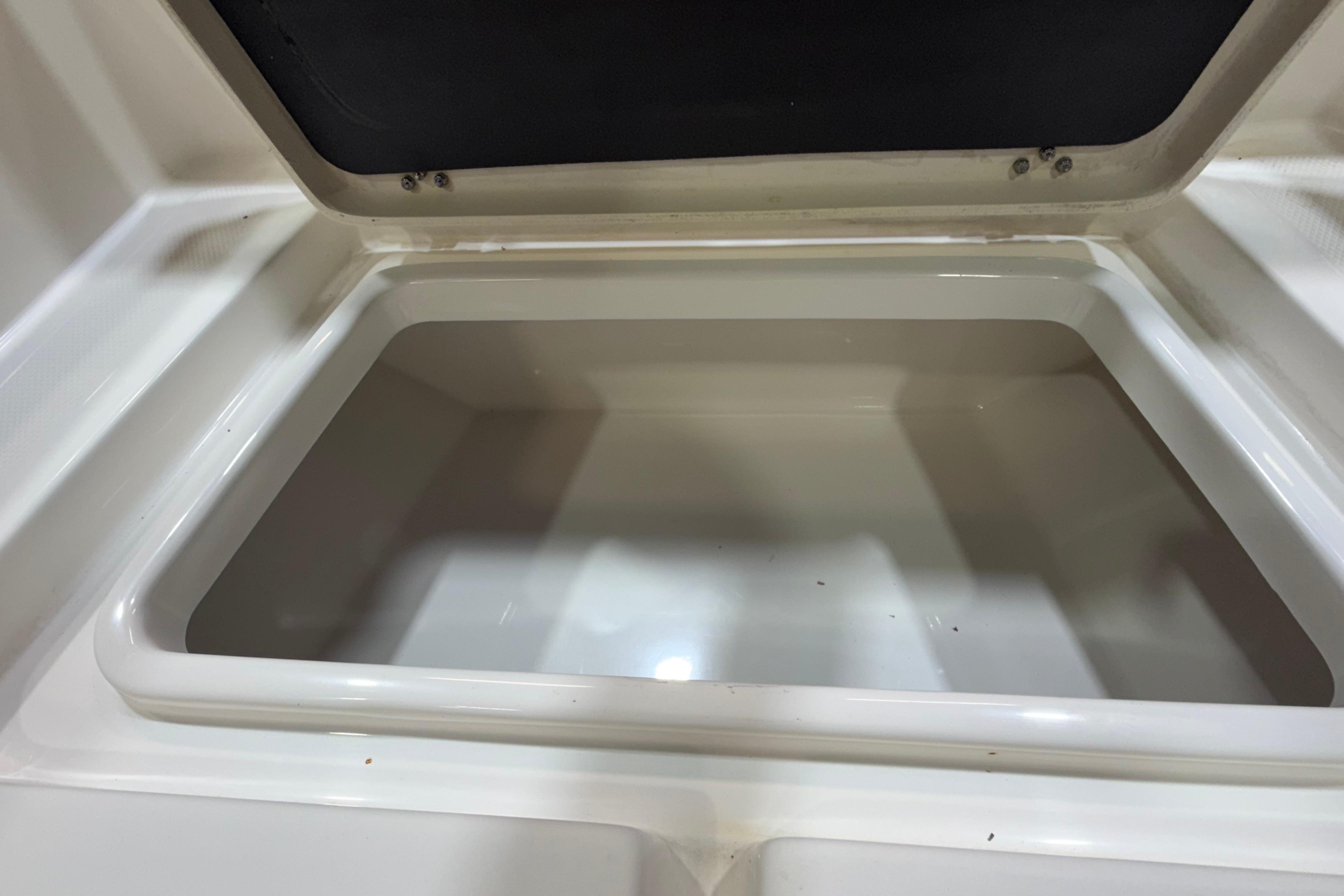 Open storage compartment on 2023 NauticStar 215 XTS boat.