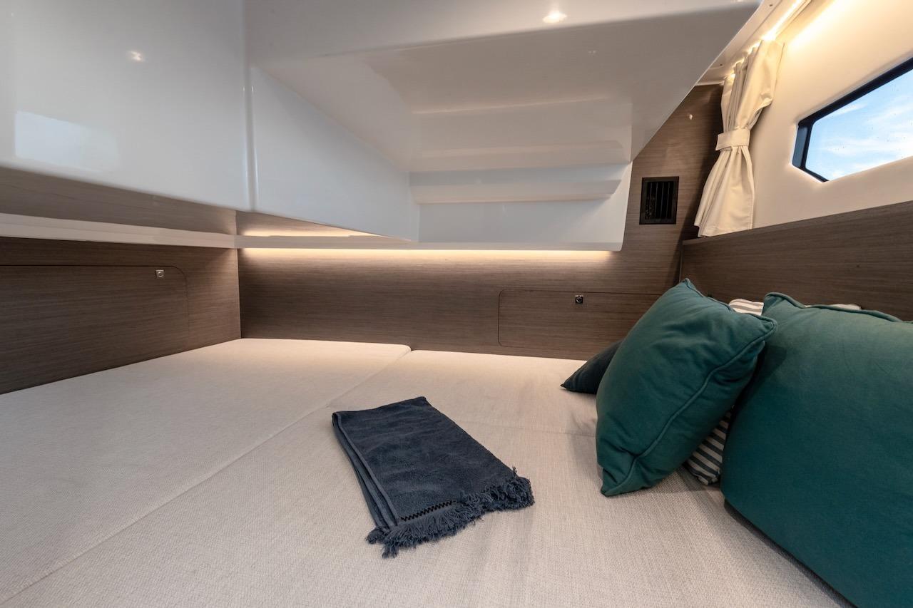 Luxurious cabin interior of 2025 Jeanneau NC 895 Series 2 with cozy bedding and cushions.