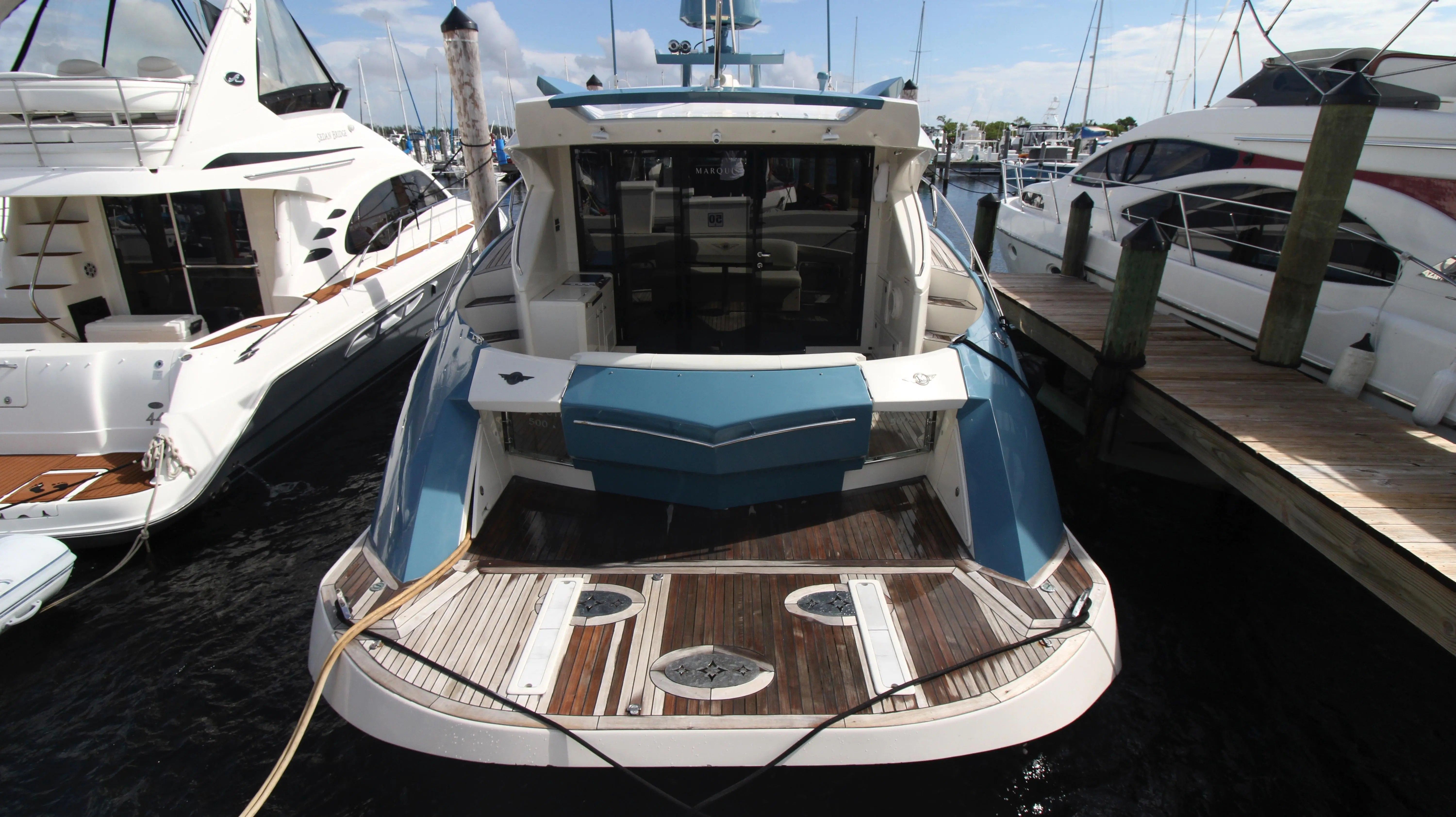 A 2010 Marquis Sport Coupe docked, surrounded by other boats.