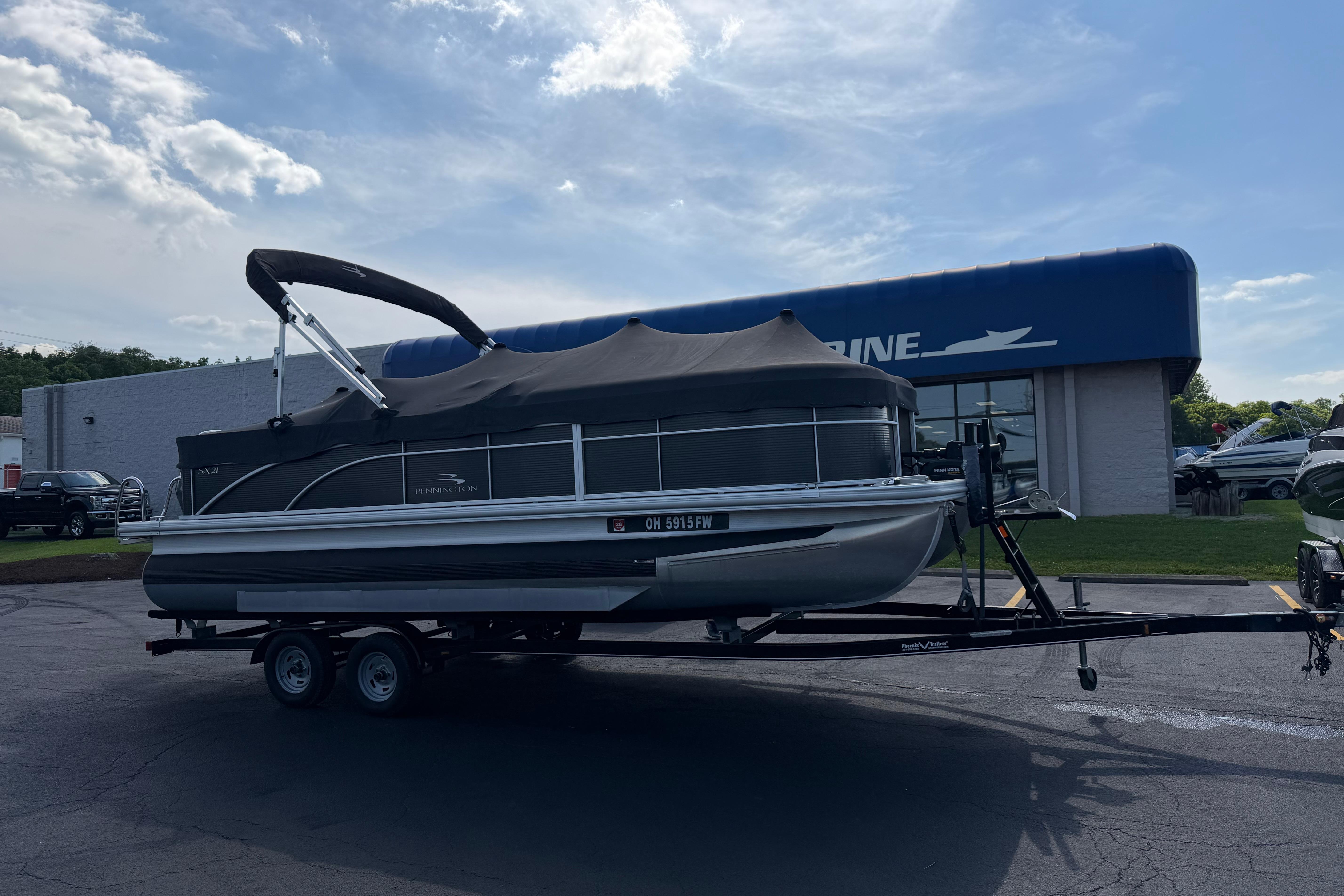 2018 Bennington 21 SF pontoon boat on trailer outside dealership.