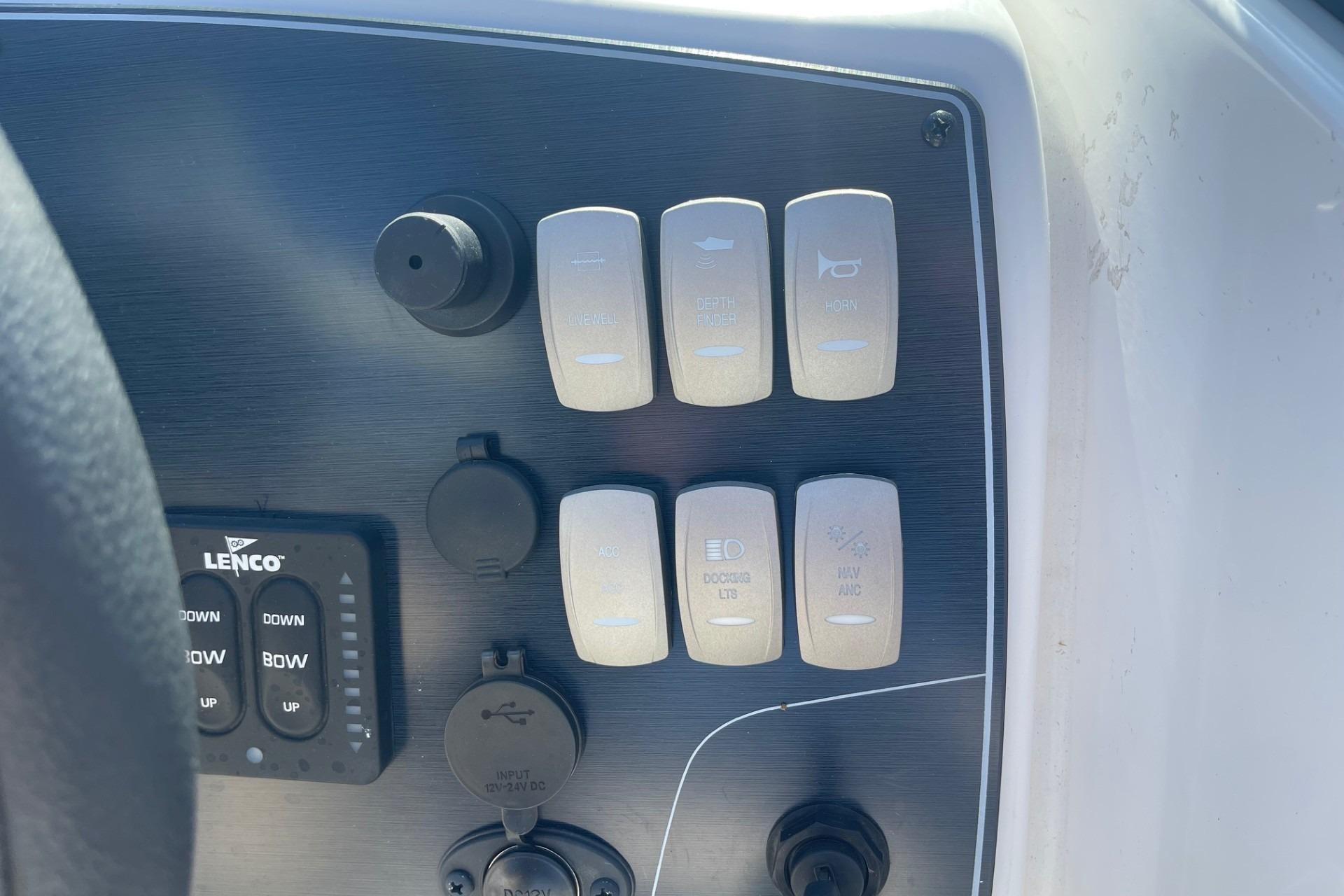 Control panel of 2023 Hurricane SunDeck 2400 OB boat with switches and buttons.