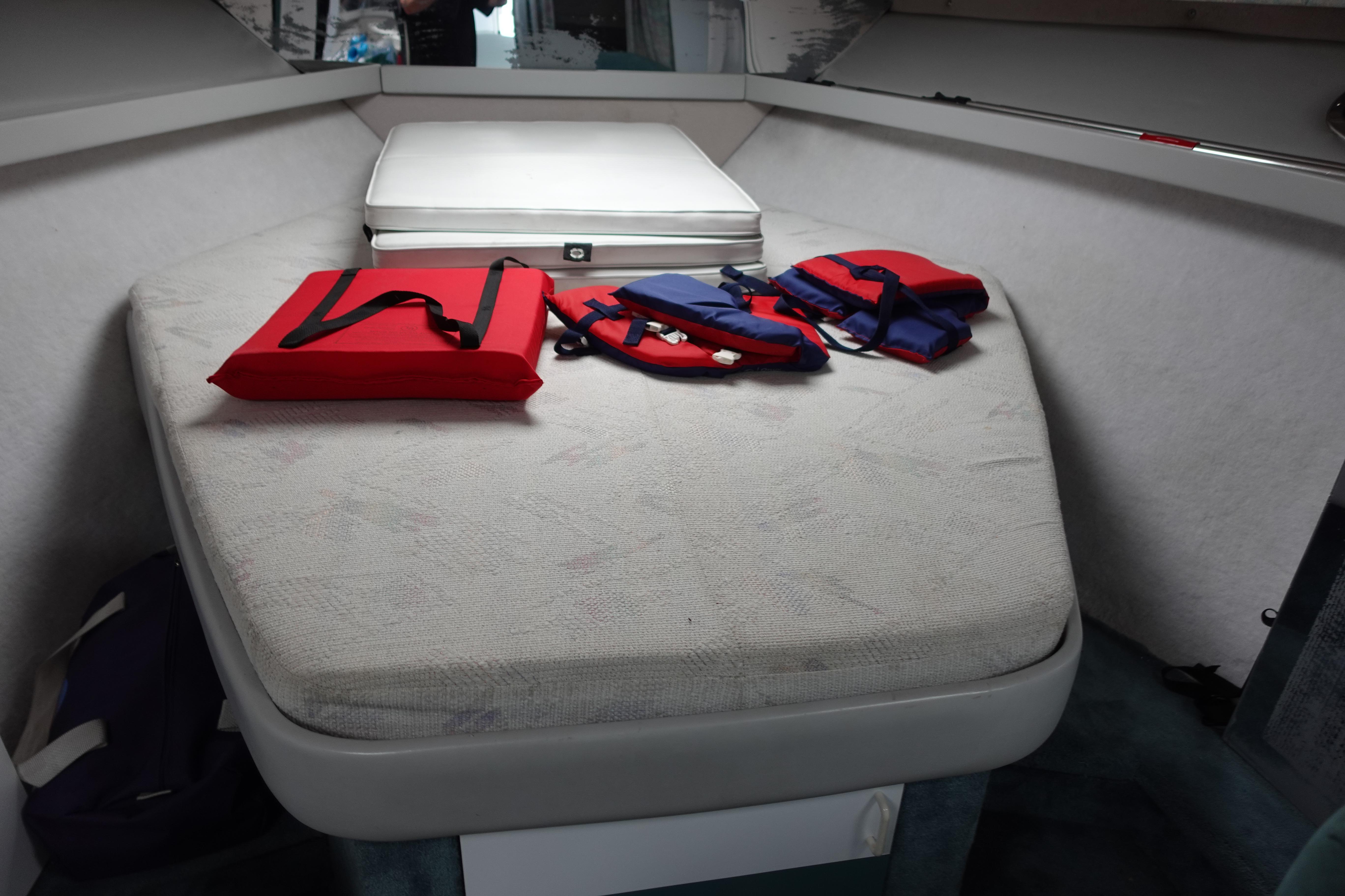 Interior cabin of 1993 Formula 34 Performance Cruiser with life jackets on bed.