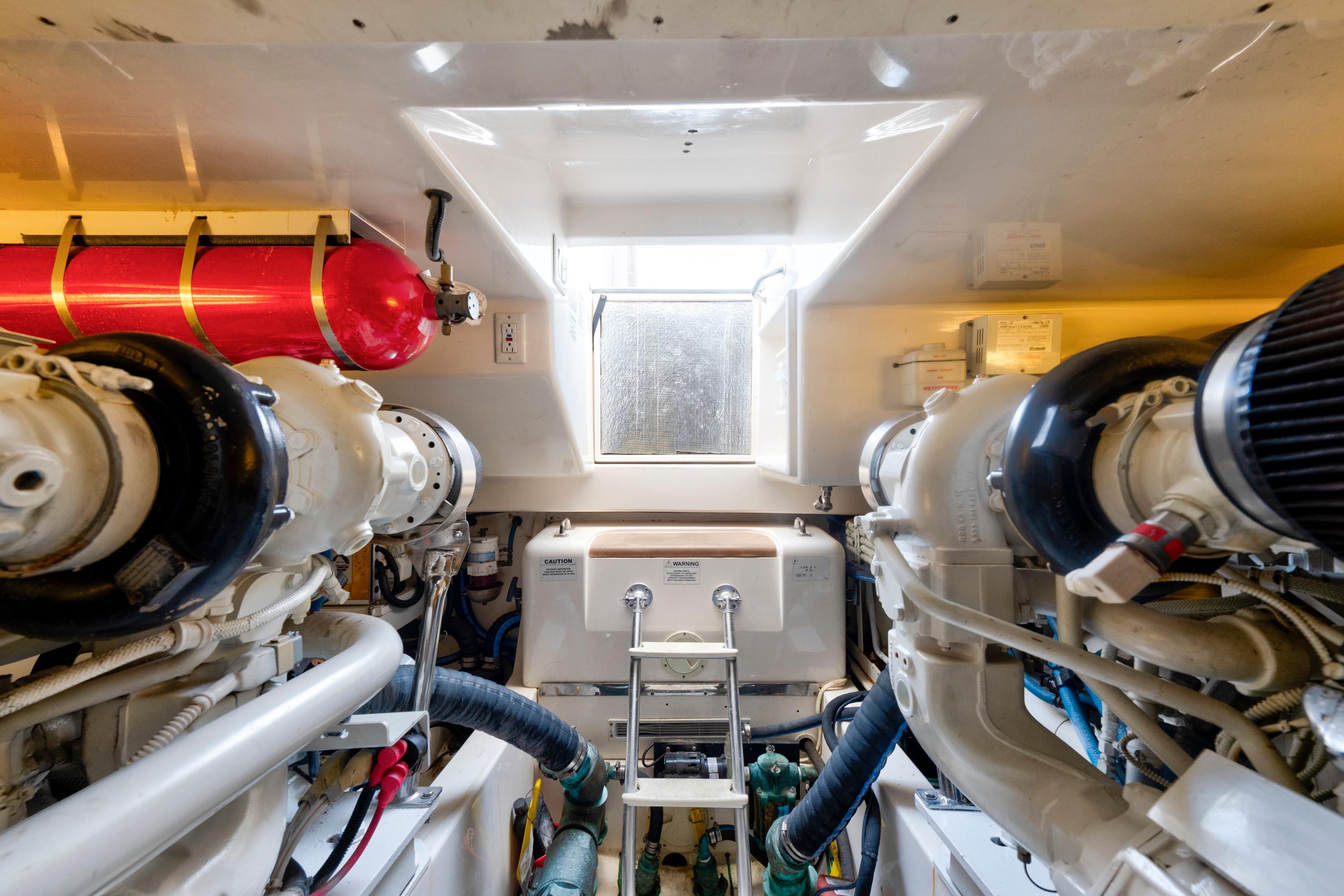 Engine room of 2010 Cabo 45 Express yacht, featuring dual engines and fire suppression system.