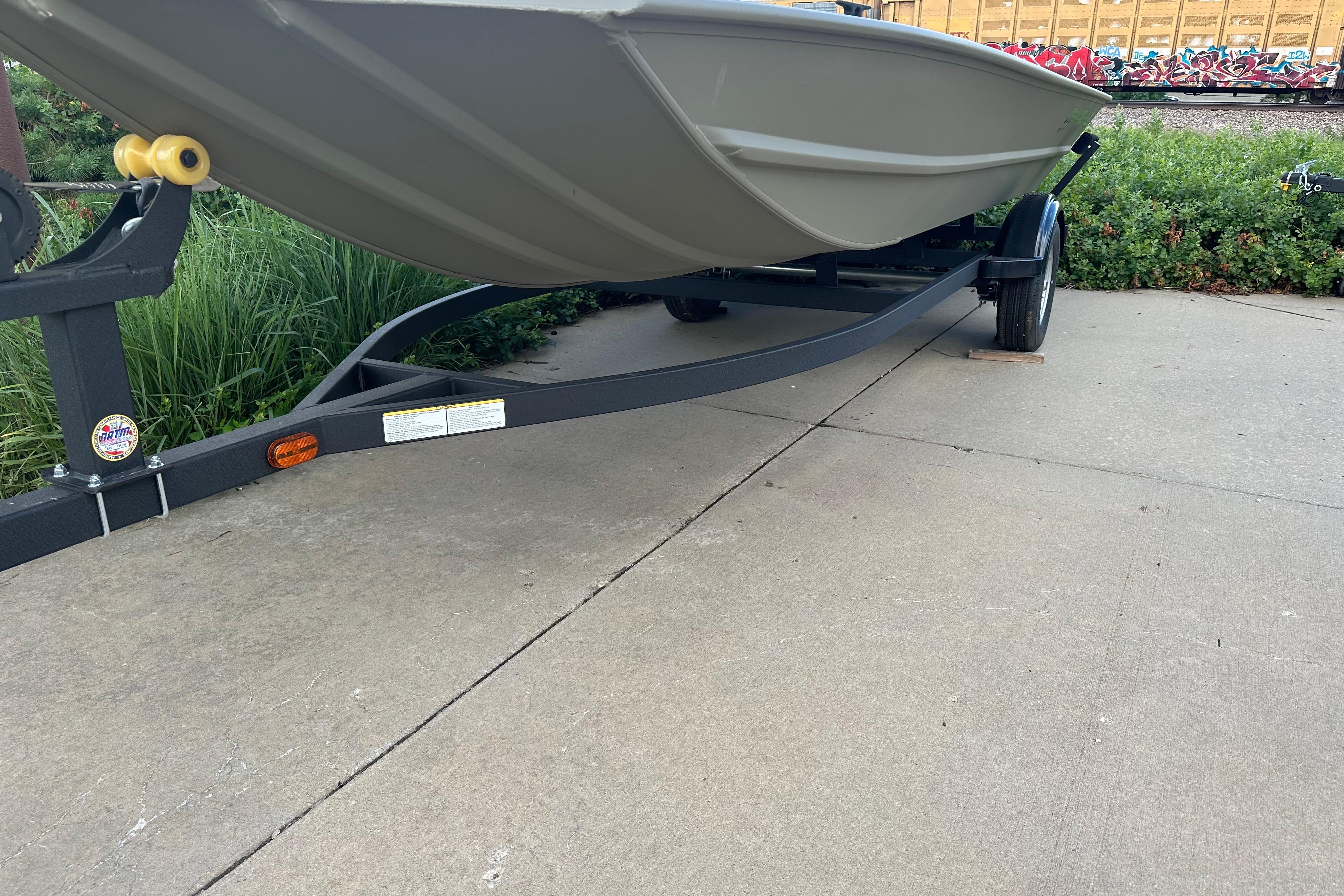 2026 Tracker Grizzly 1754 Utility boat on trailer, parked on concrete surface.