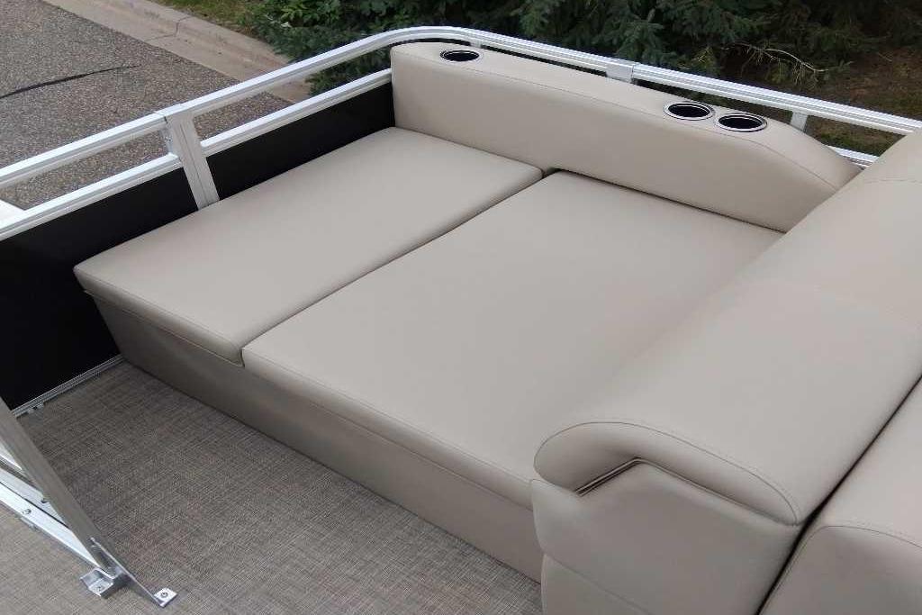 2025 Sun Tracker Sportfish 24 XP3 boat seating with beige upholstery and cup holders.
