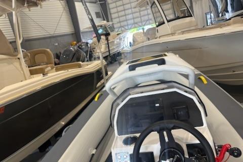 2026 Highfield Velox 420 boat in a showroom, surrounded by other vessels.