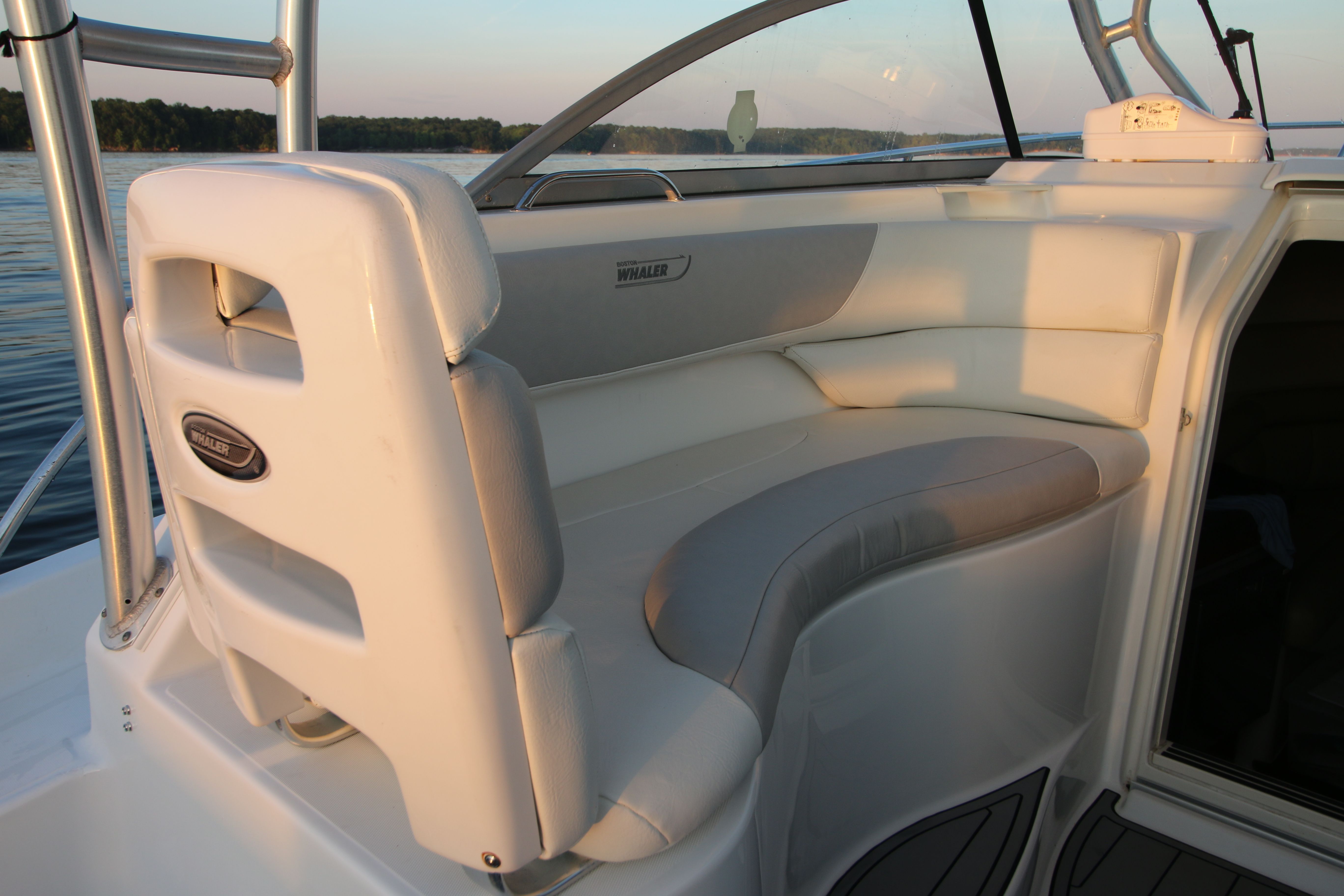 2006 Boston Whaler 305 Conquest with curved white seating and a clear view of the water.