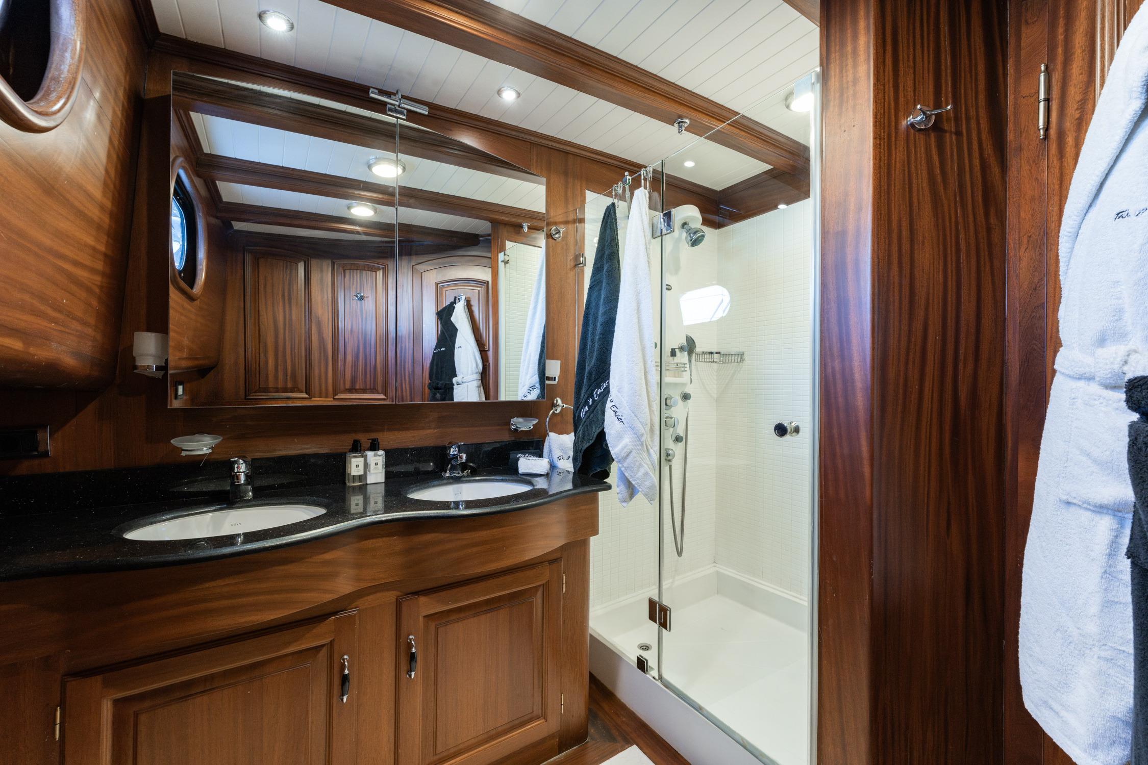 Luxurious bathroom in 2007 Custom Gulet Motorsailer with wood accents and dual sinks.