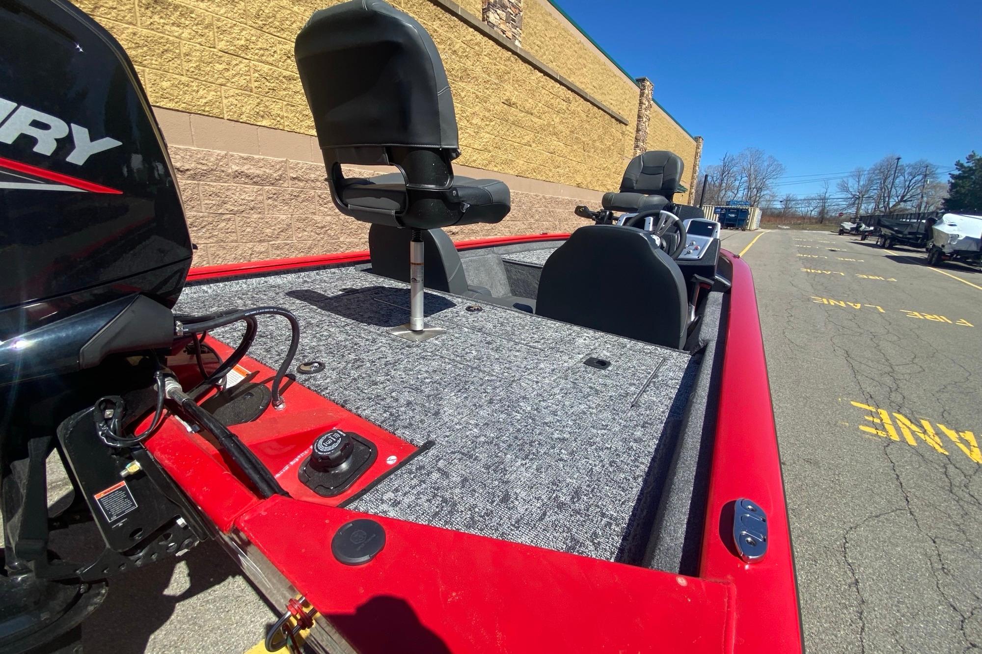 2026 Tracker Pro Team 175 boat with red exterior and gray interior, parked outdoors.