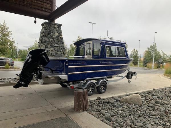 2023 Spartan 220 Maximus Pro boat on trailer, parked outdoors.
