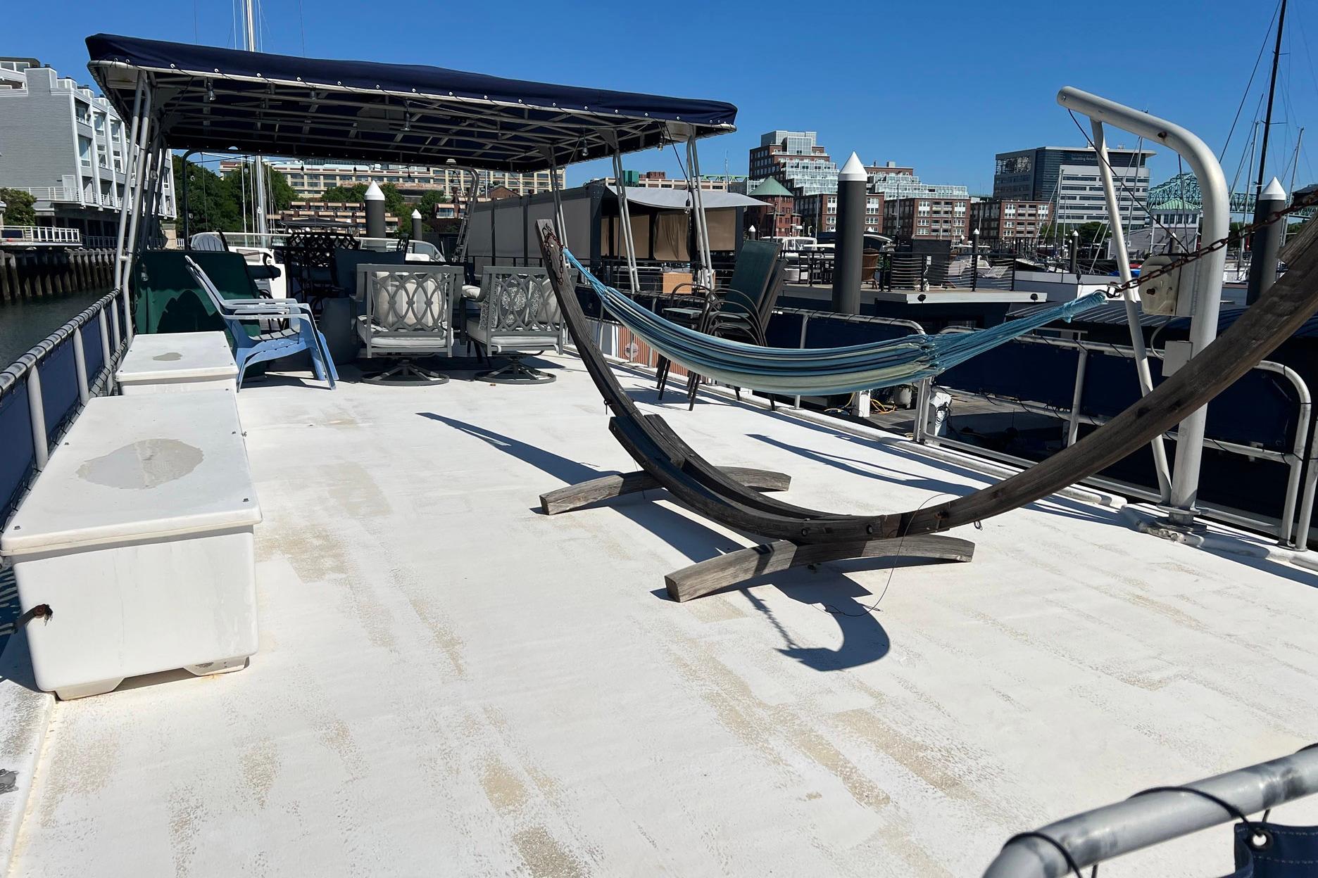 1993 Sumerset houseboat deck with hammock, seating, and canopy in a marina setting.