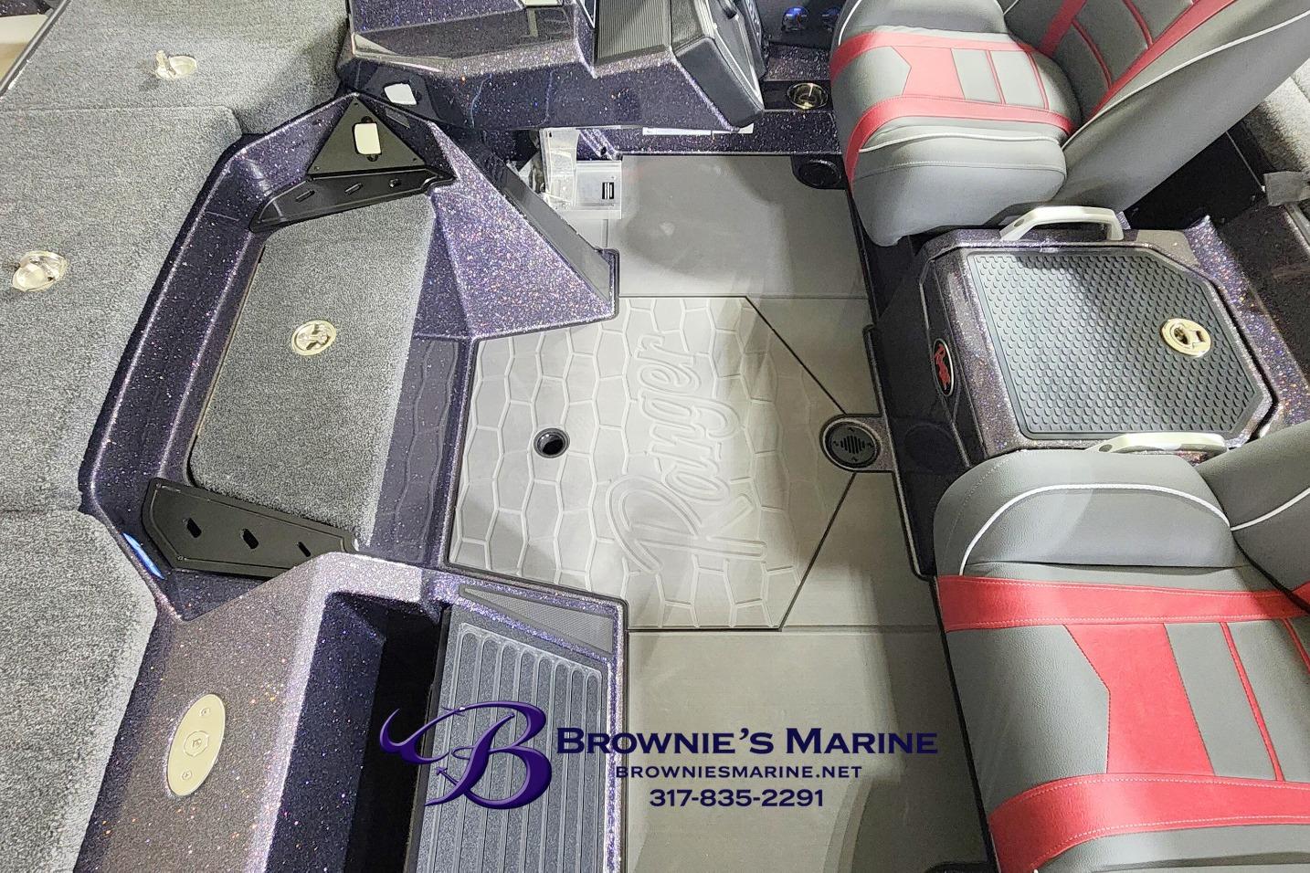 2026 Ranger Z521 boat interior with red and gray seats, branded flooring, and storage compartments.