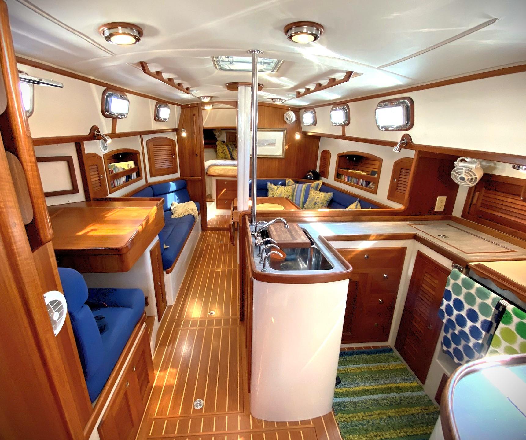 Luxurious interior of a 2005 Pacific Seacraft 40 sailboat with wood finishes and blue seating.