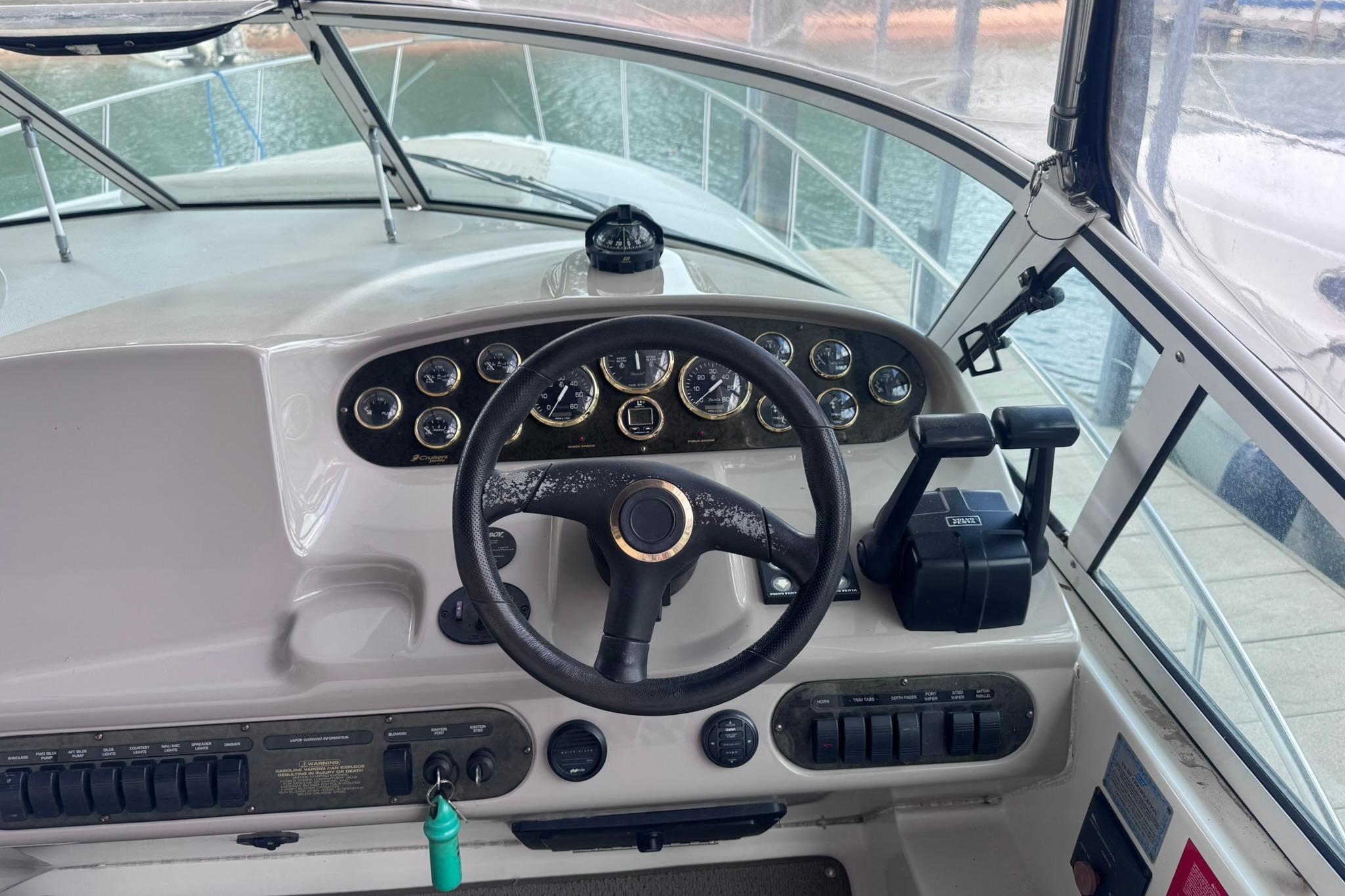 Helm of 2002 Cruisers Yachts 3275 Express with steering wheel and control panel.
