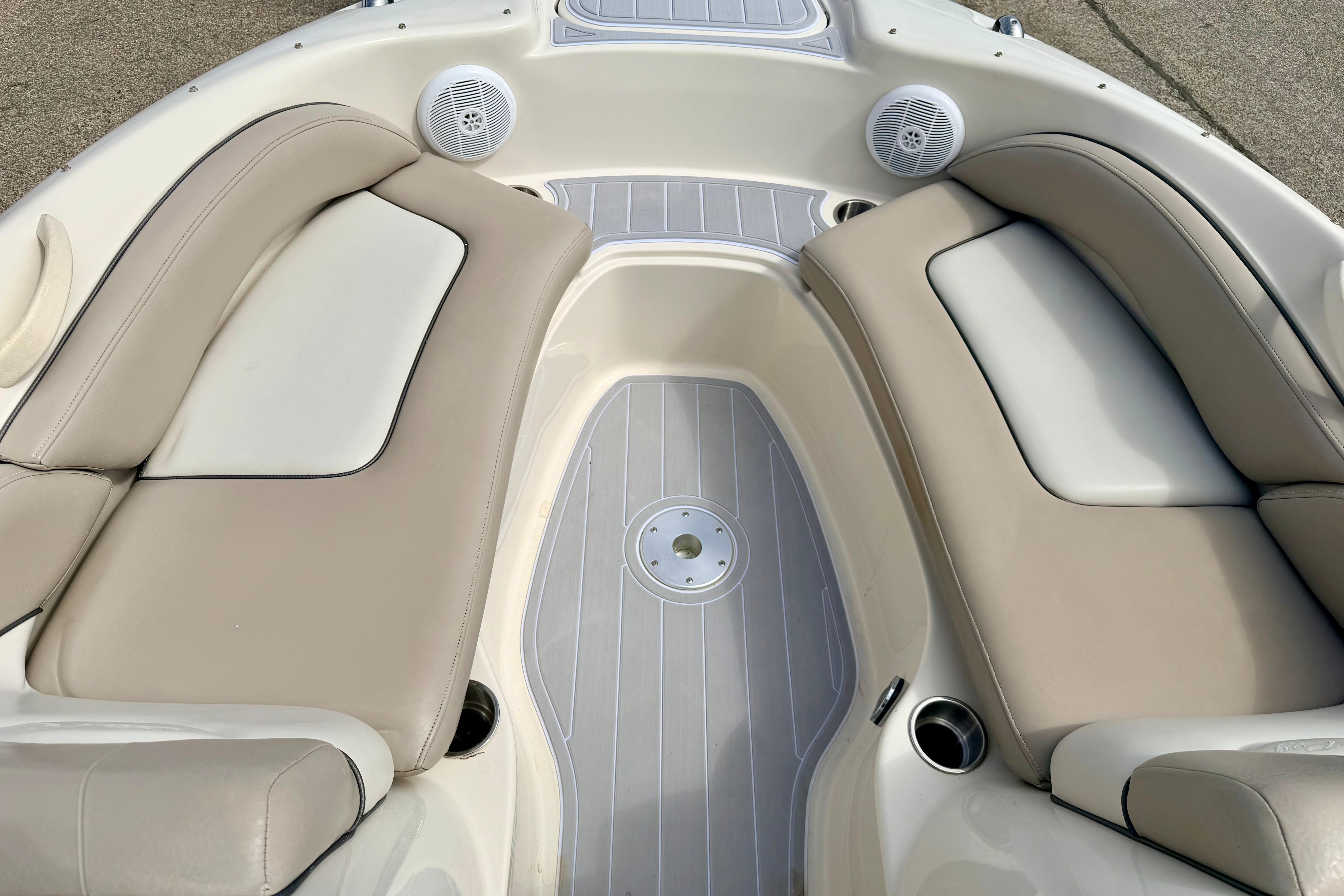 Interior seating of 2003 Sea Ray 200 Sundeck boat with beige cushions and speakers.