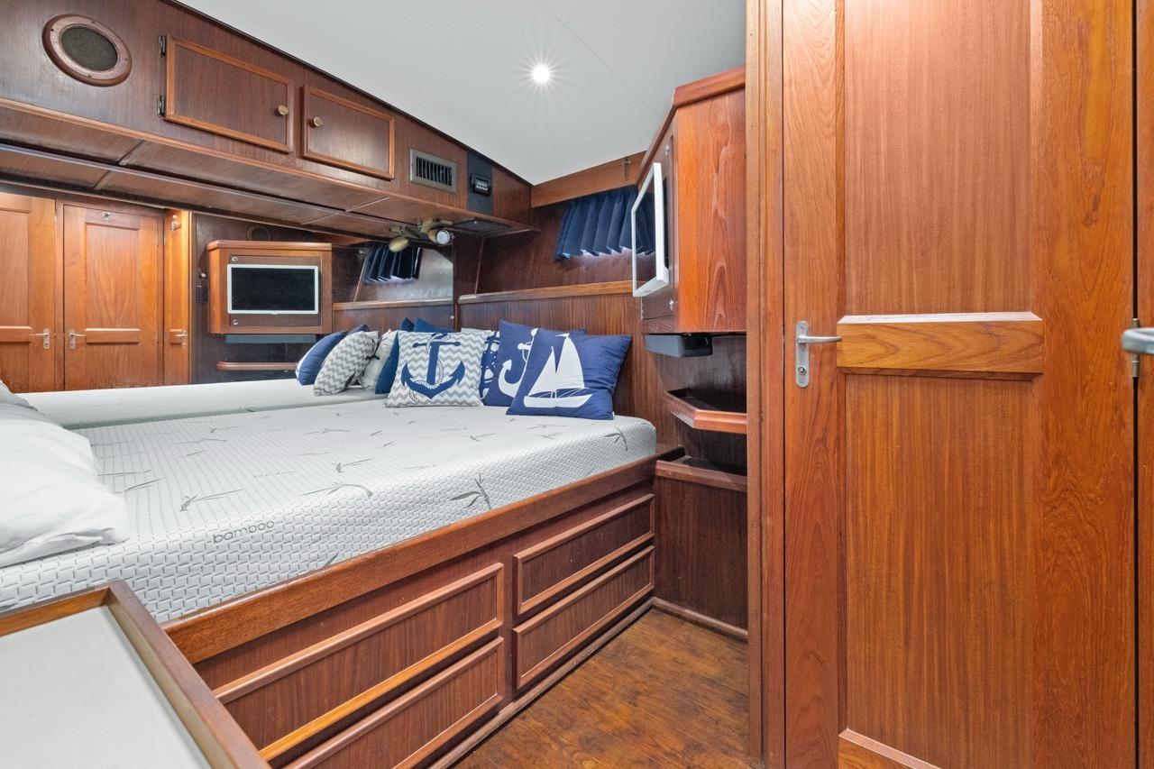 1978 Hatteras 45 Convertible yacht cabin with wooden interior and nautical-themed pillows.