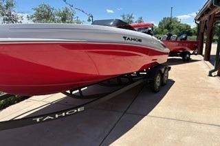 2026 Tahoe T21 boat in red on a trailer, parked outdoors.