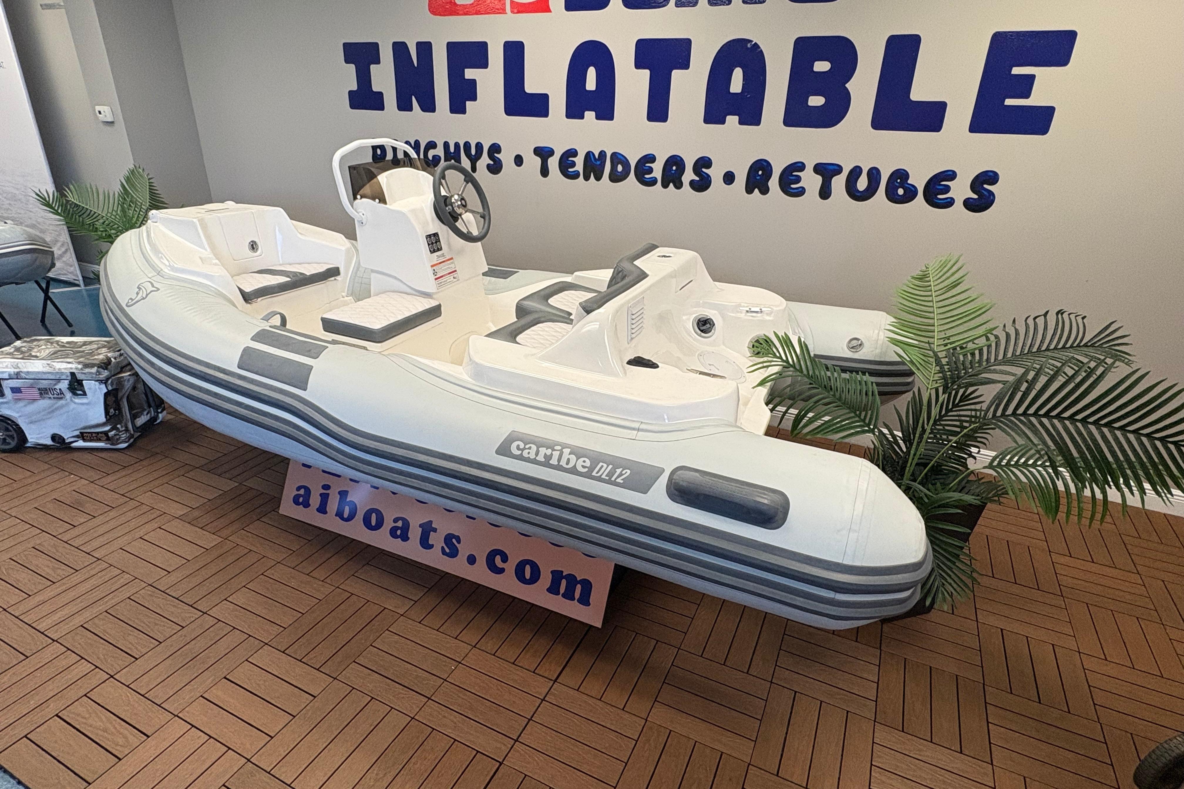 Inflatable Caribe DL12 boat, 2026 model, displayed indoors with promotional signage.