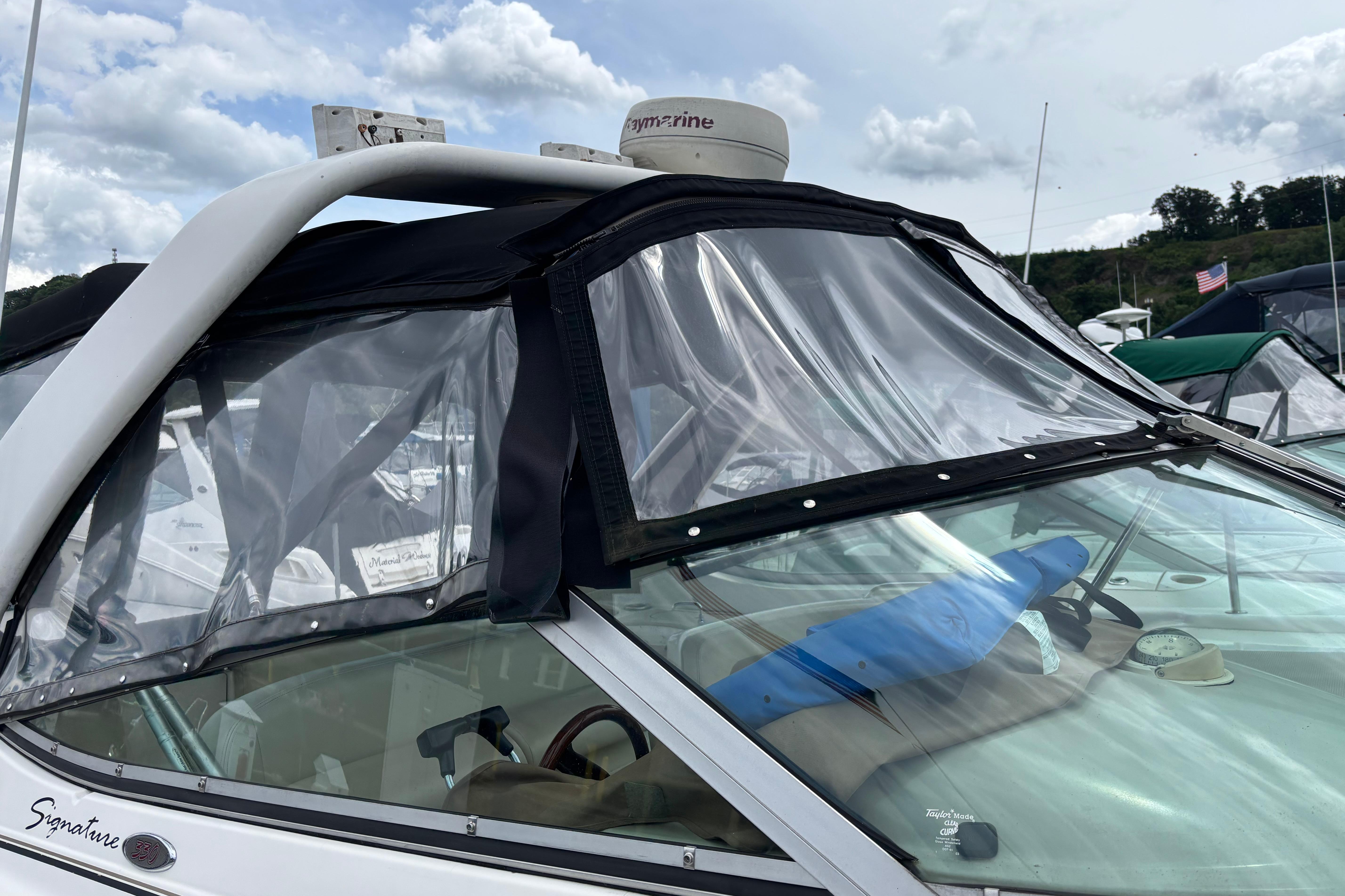 2004 Chaparral Signature 330 boat with clear canopy and radar, docked under cloudy skies.