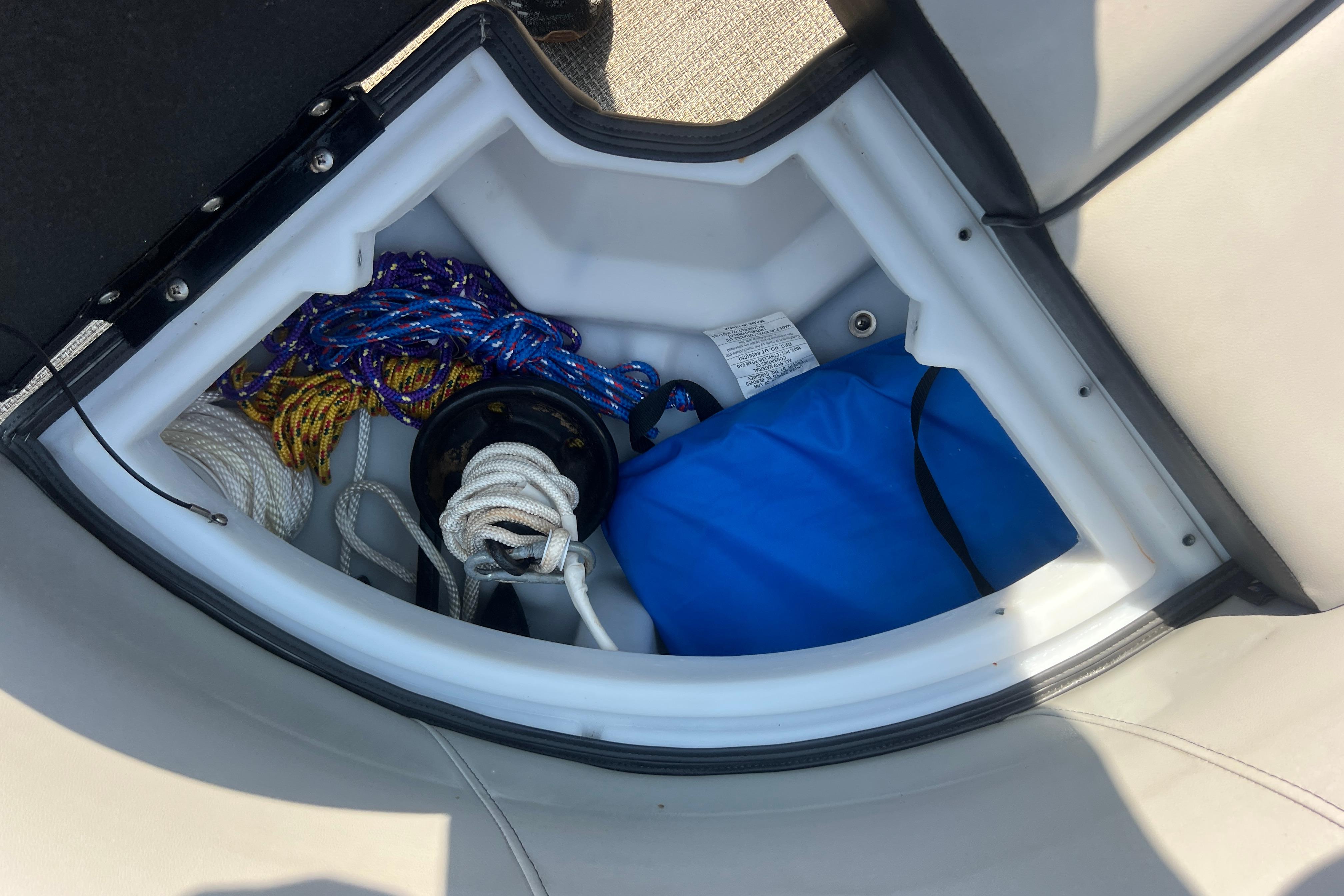 Storage compartment in a 2022 Viaggio Lago V-U 22 boat with ropes and gear.