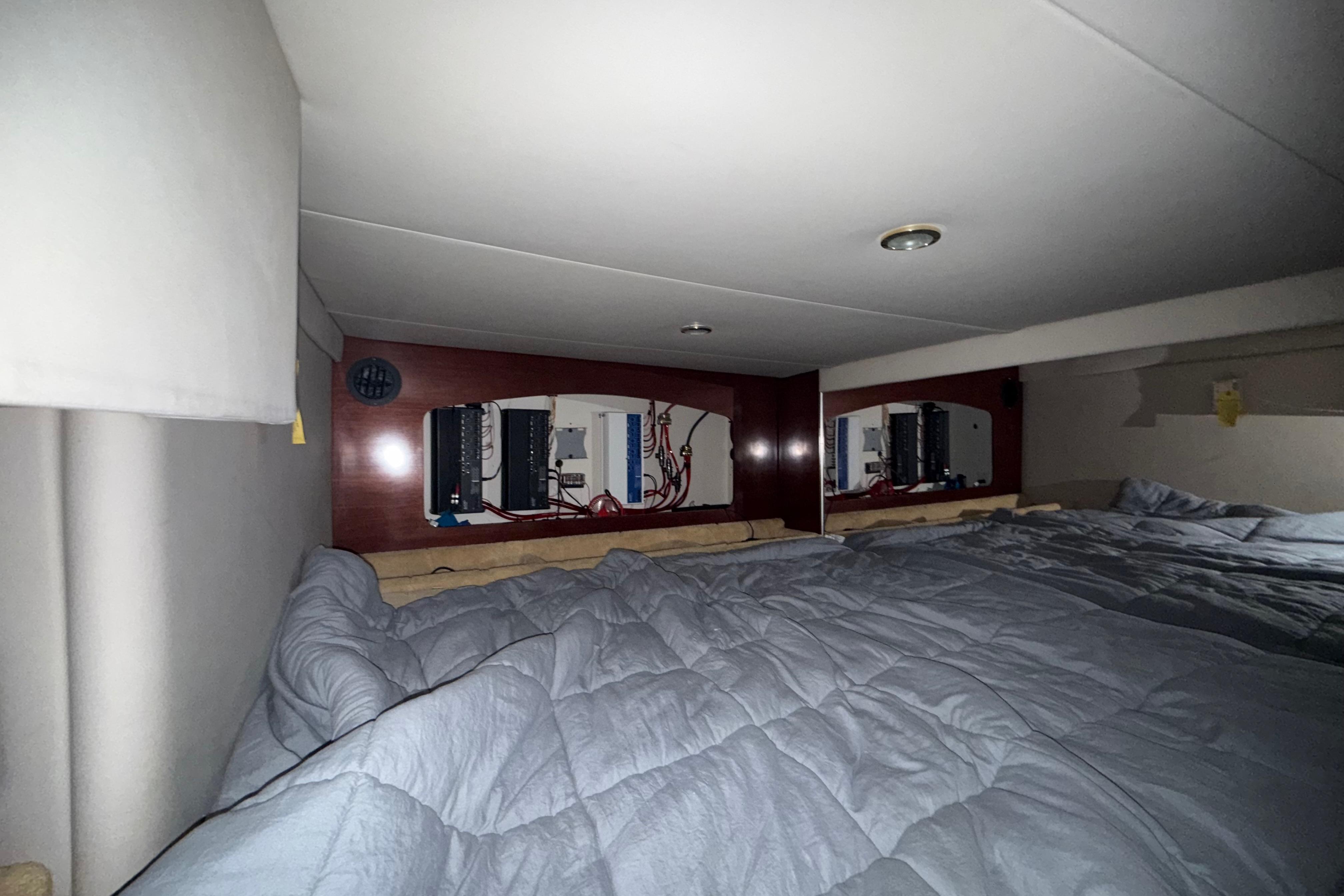 Interior cabin of a 2004 Formula 370 Super Sport boat with bedding and control panels.