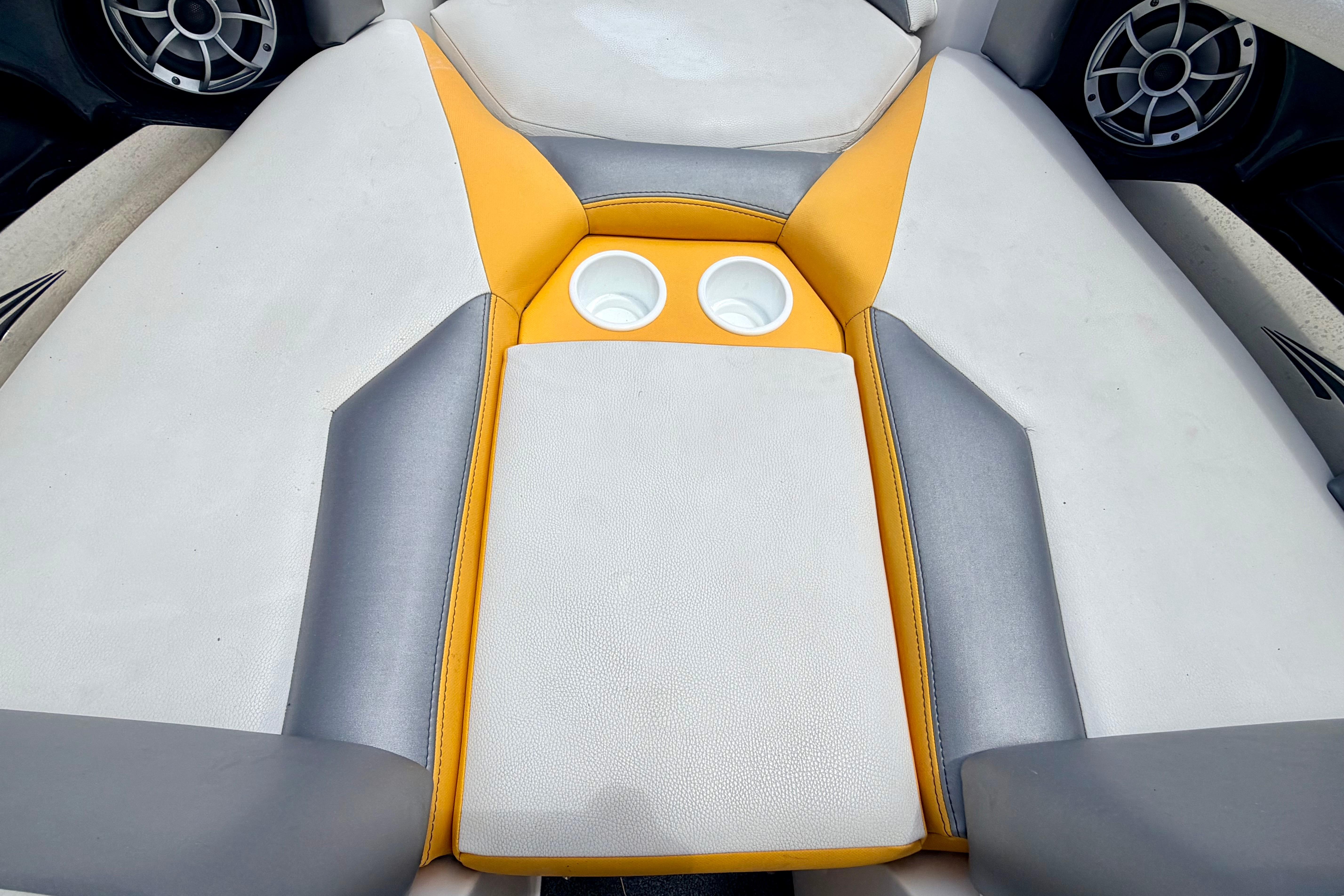 2014 Tigé R20 boat interior with gray and yellow upholstery, featuring dual cup holders.