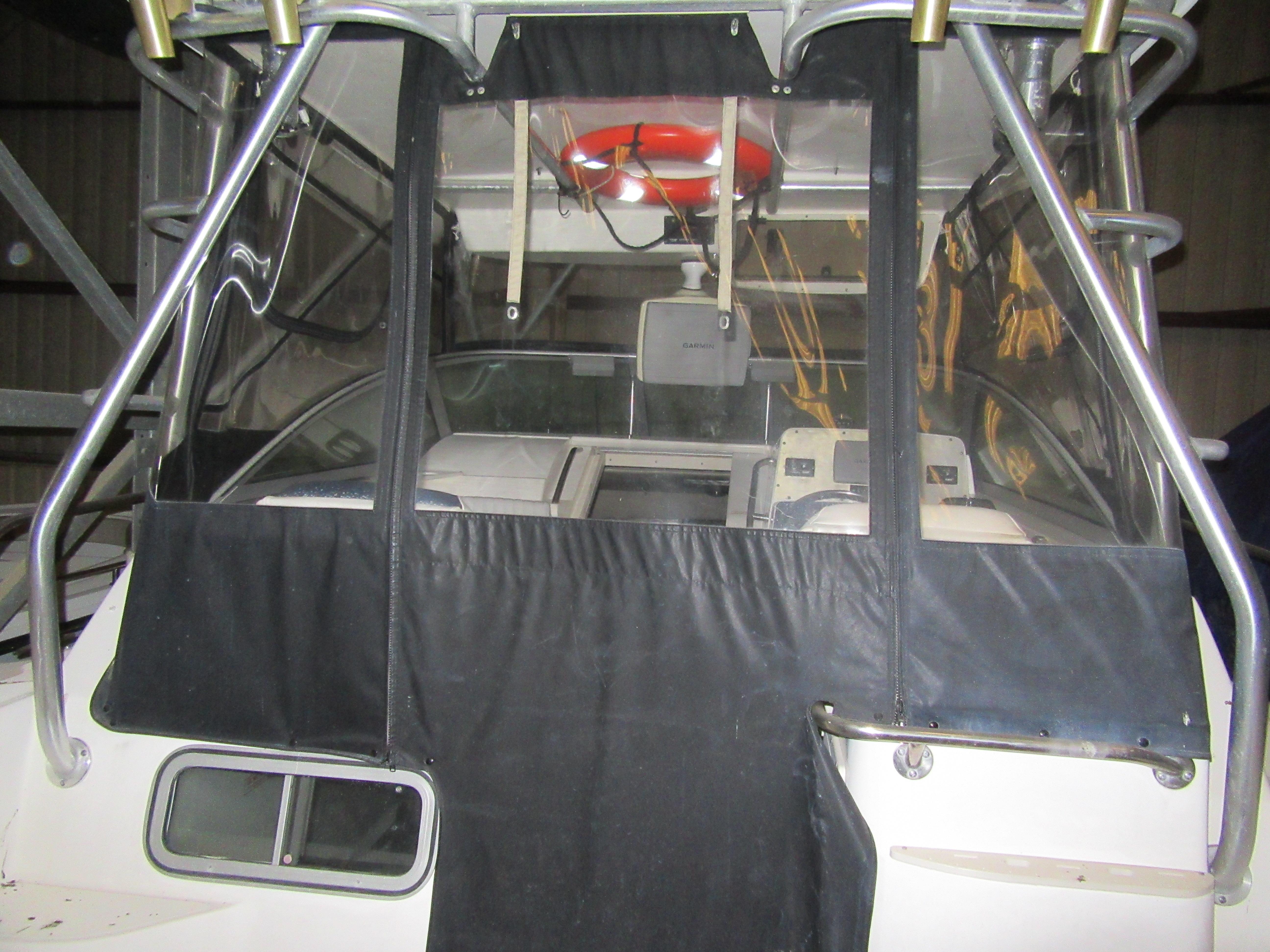 2002 Boston Whaler 295 Conquest boat cockpit with black canvas cover and life preserver.