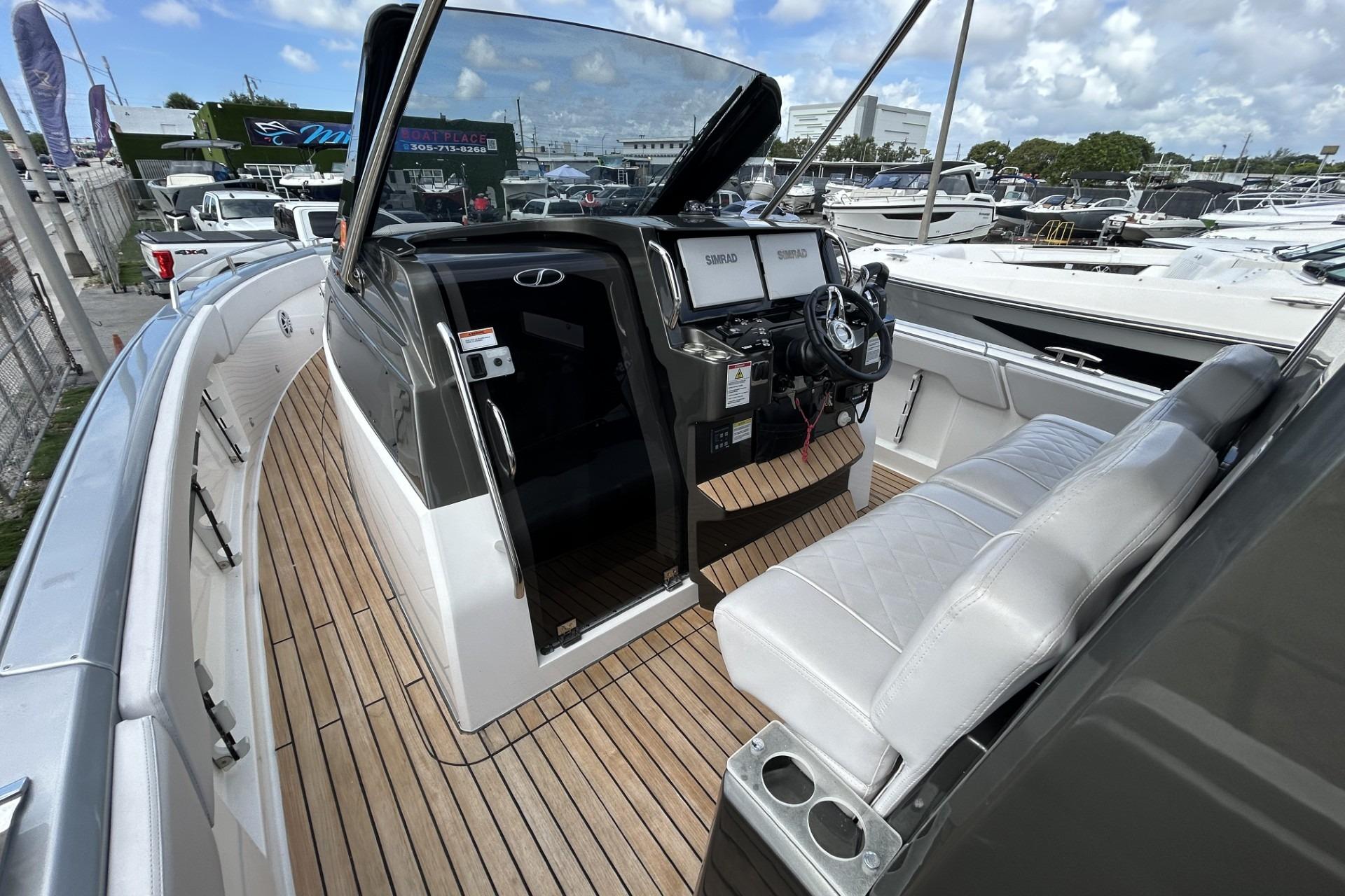 2023 Schaefer V33 boat interior with modern helm, dual screens, and cushioned seating.