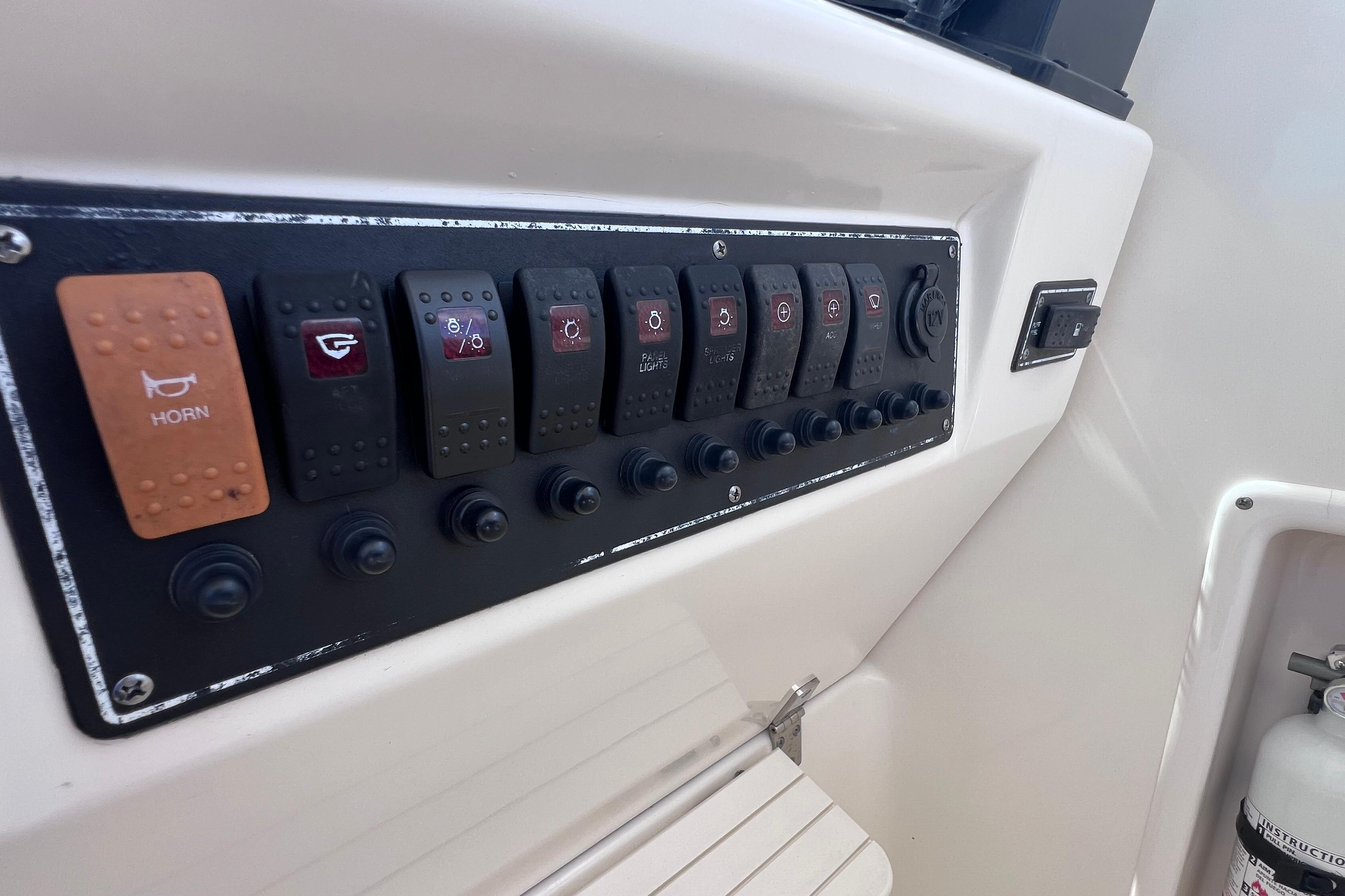 Control panel of a 2004 Pursuit 2870 Walkaround boat with labeled switches.