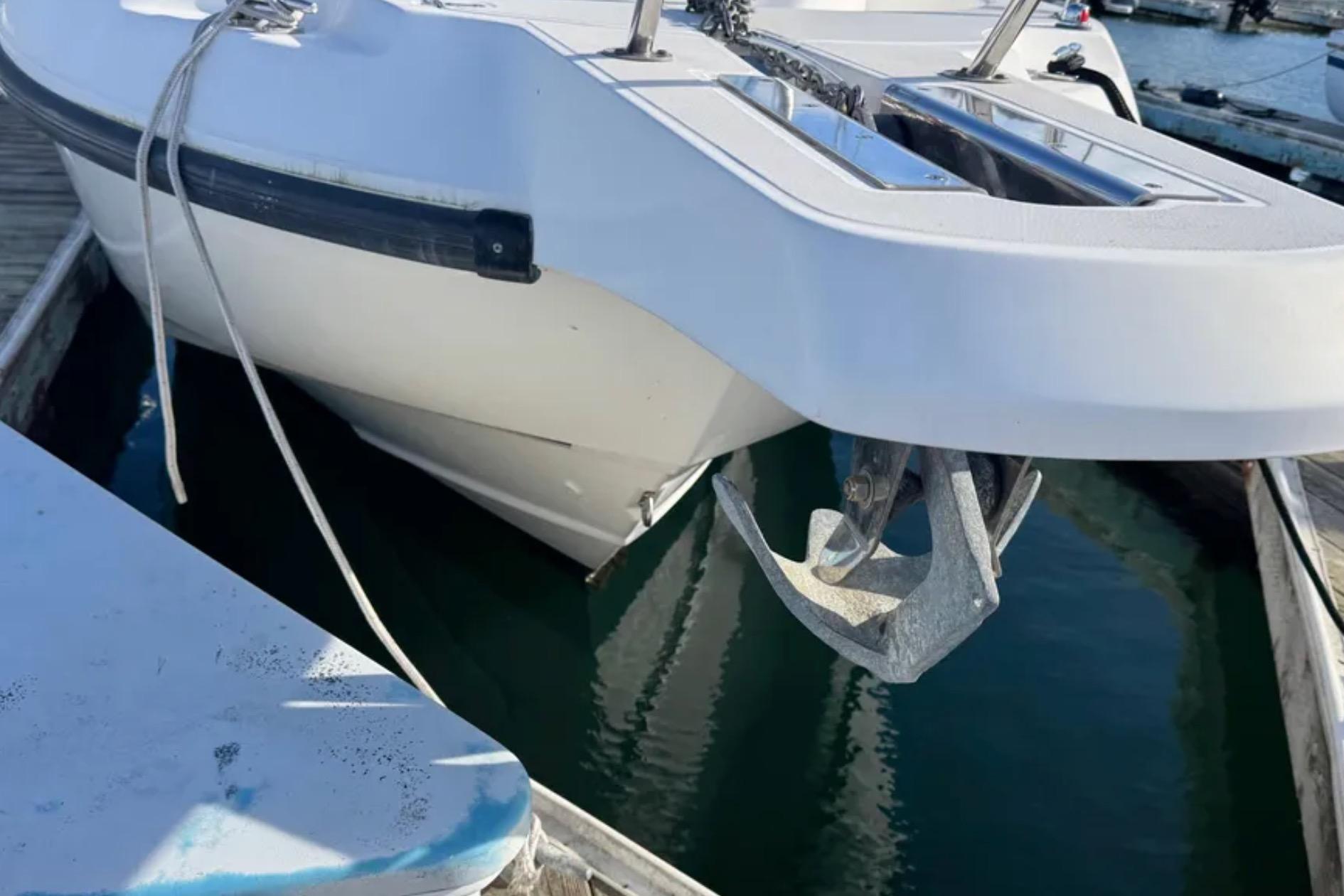 2004 Boston Whaler 255 Conquest boat with anchor, docked at marina.