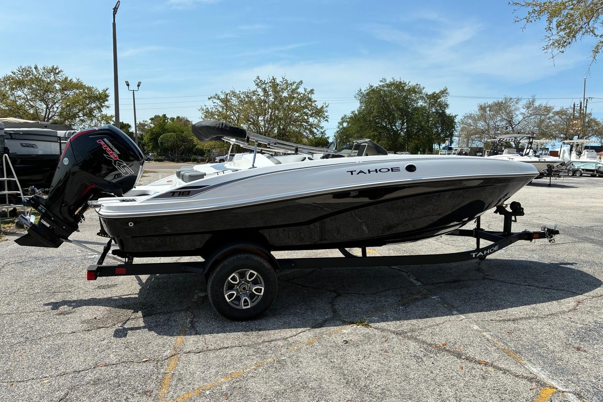 2026 Tahoe T18 boat on trailer in parking lot, side view.
