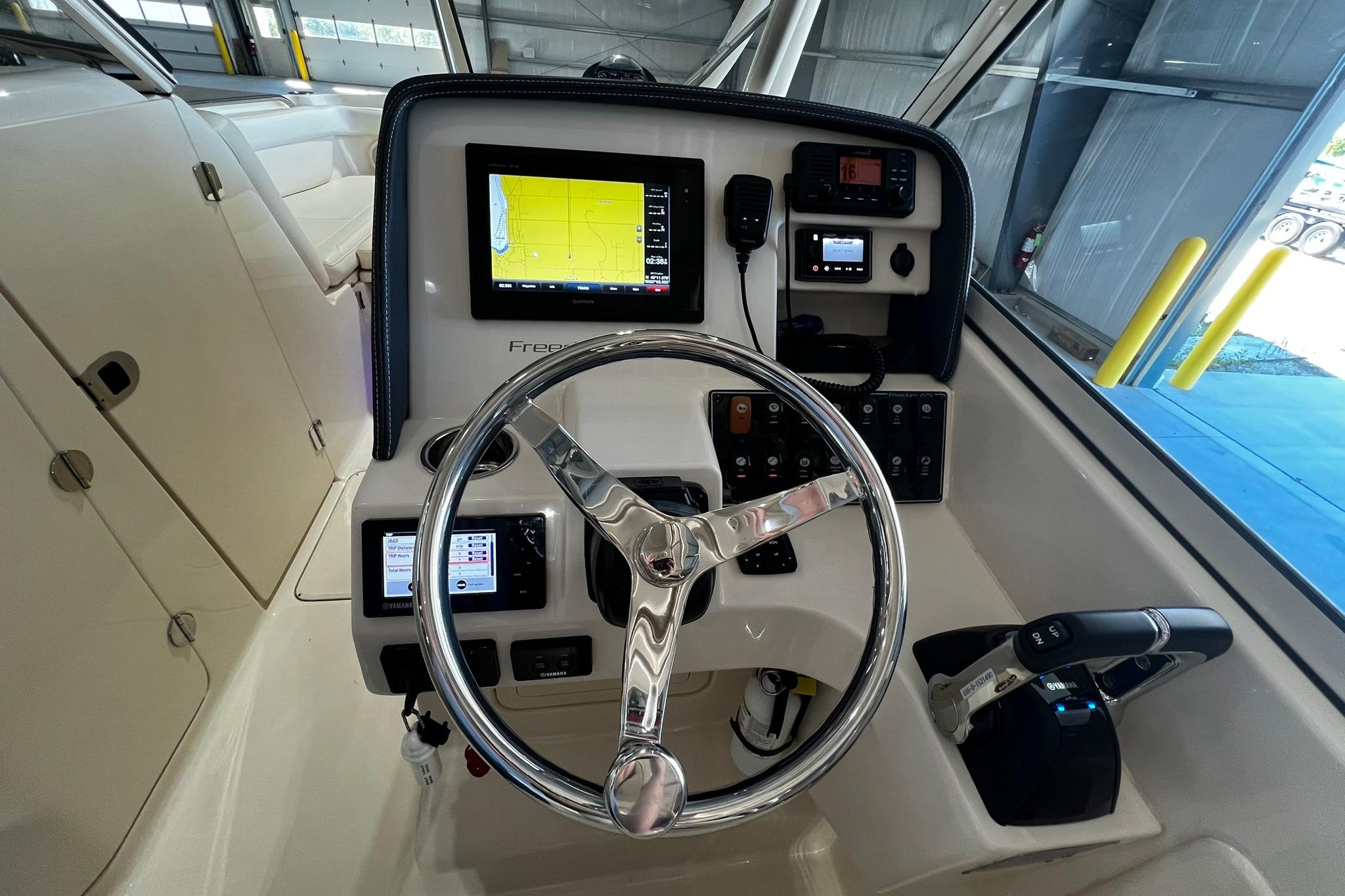 2014 Grady-White Freedom 275 helm with steering wheel and navigation controls.