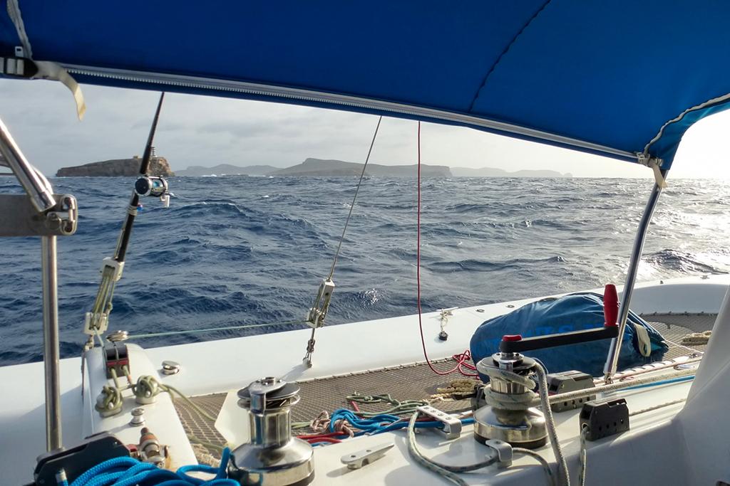 Trimaran Polynésie 42 sailing on open sea, view from cockpit, under blue canopy, 2008 model.