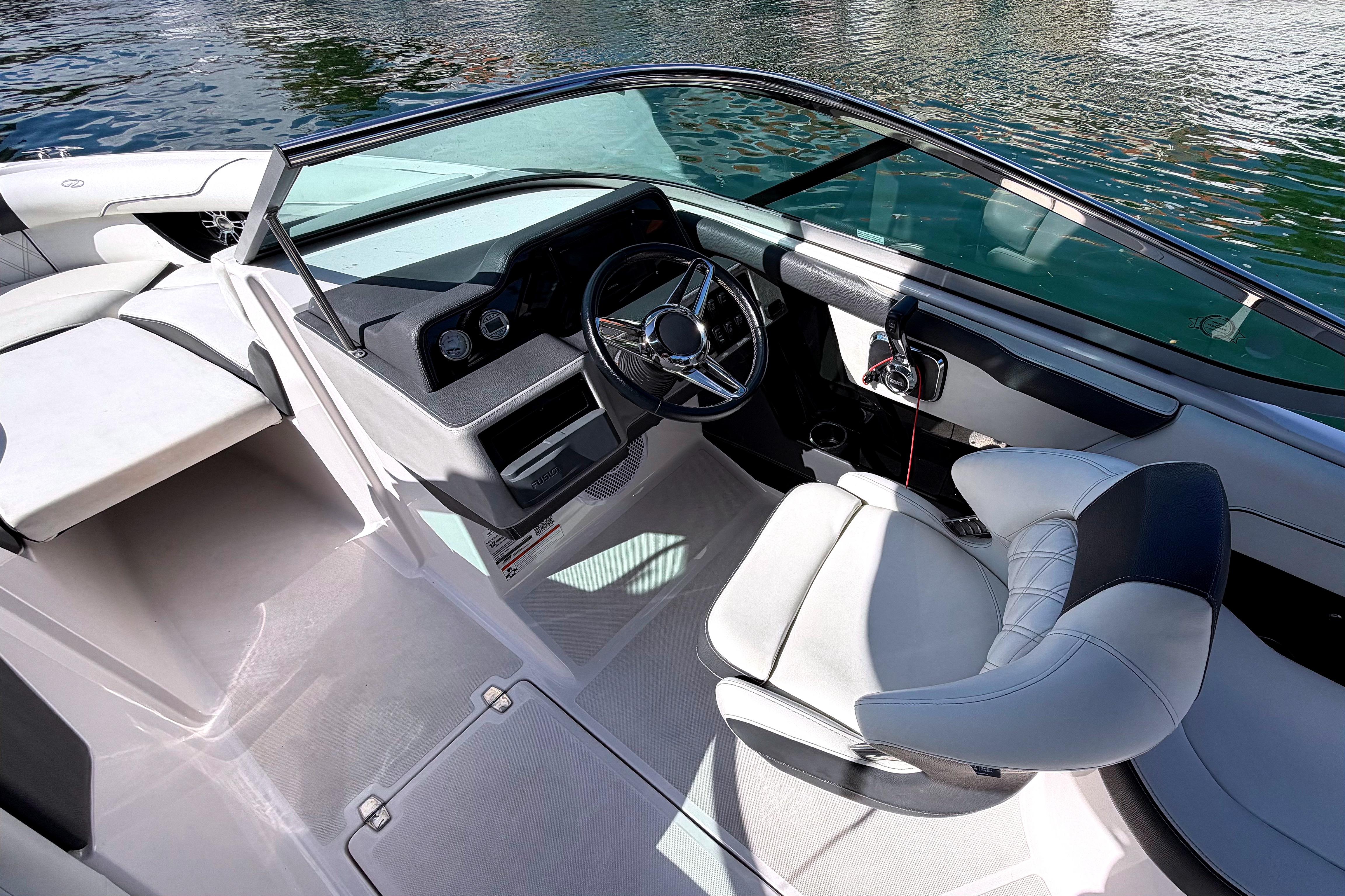 2020 Regal 2300 Bowrider interior with steering wheel and seating, on calm water.
