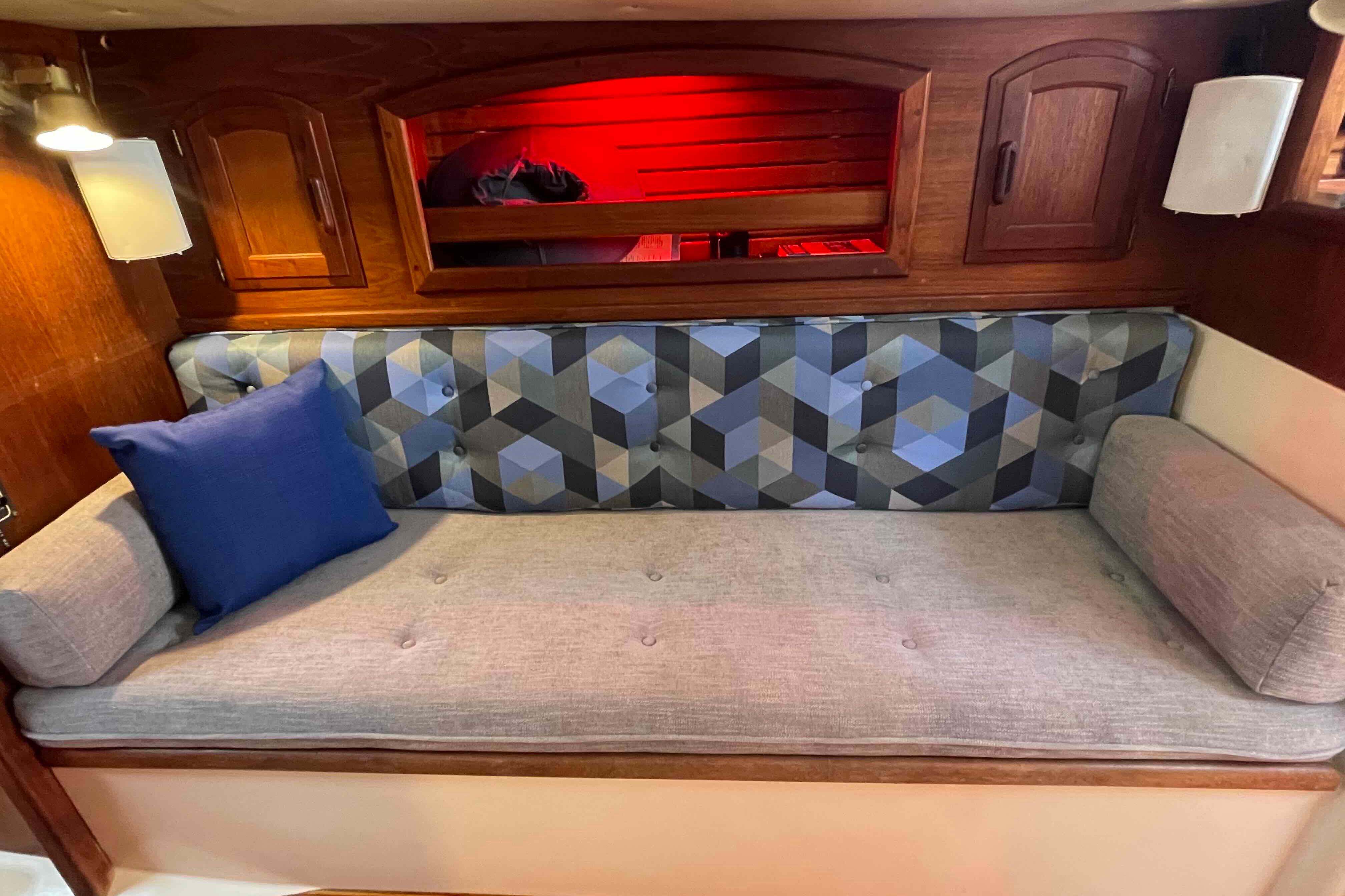 Cozy interior of 1987 Pacific Seacraft 34 sailboat with geometric-patterned cushions.